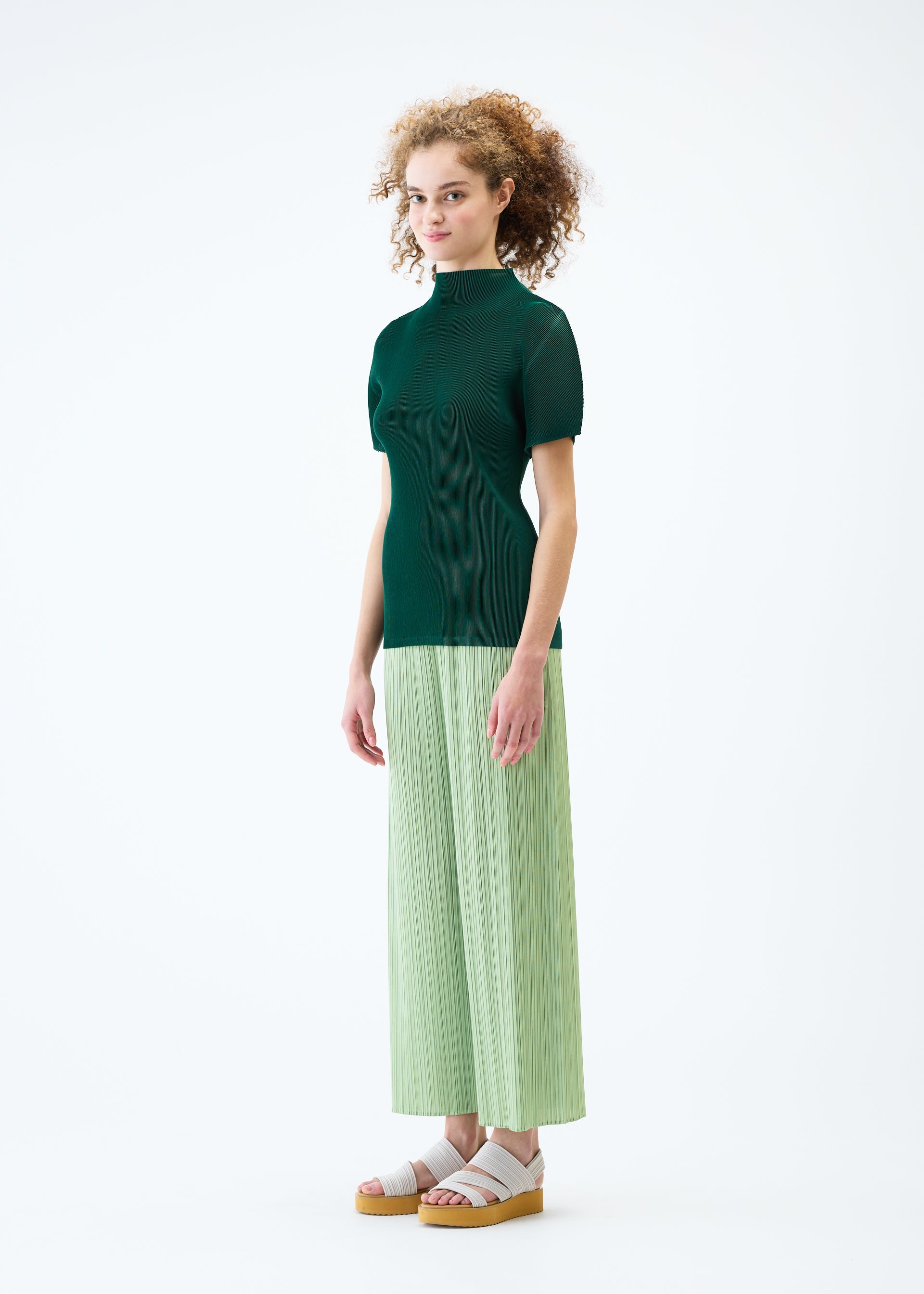 A model wears the PLEATS PLEASE ISSEY MIYAKE MIST JUNE top.