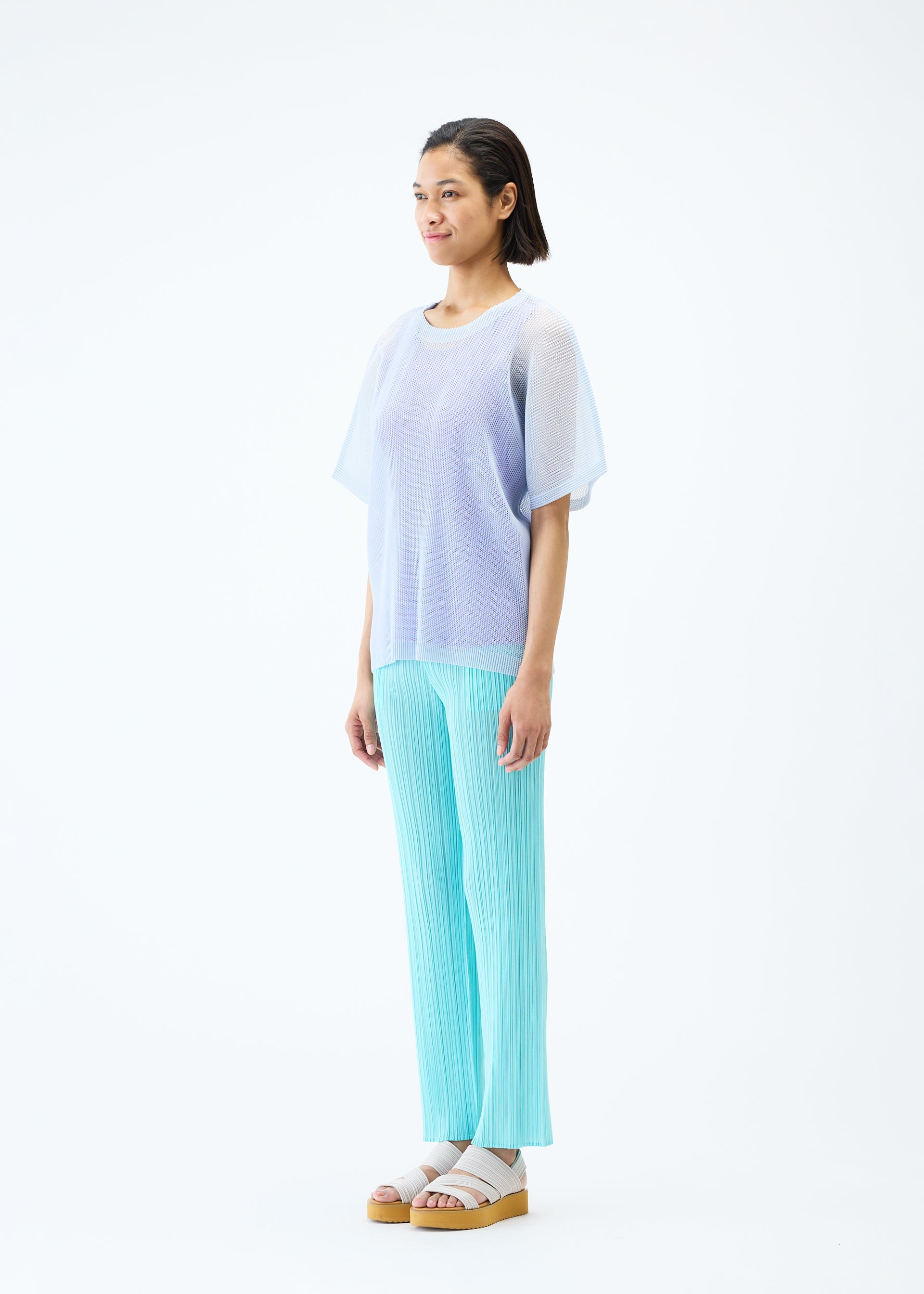A model wears the PLEATS PLEASE ISSEY MIYAKE TATAMI APRIL top.