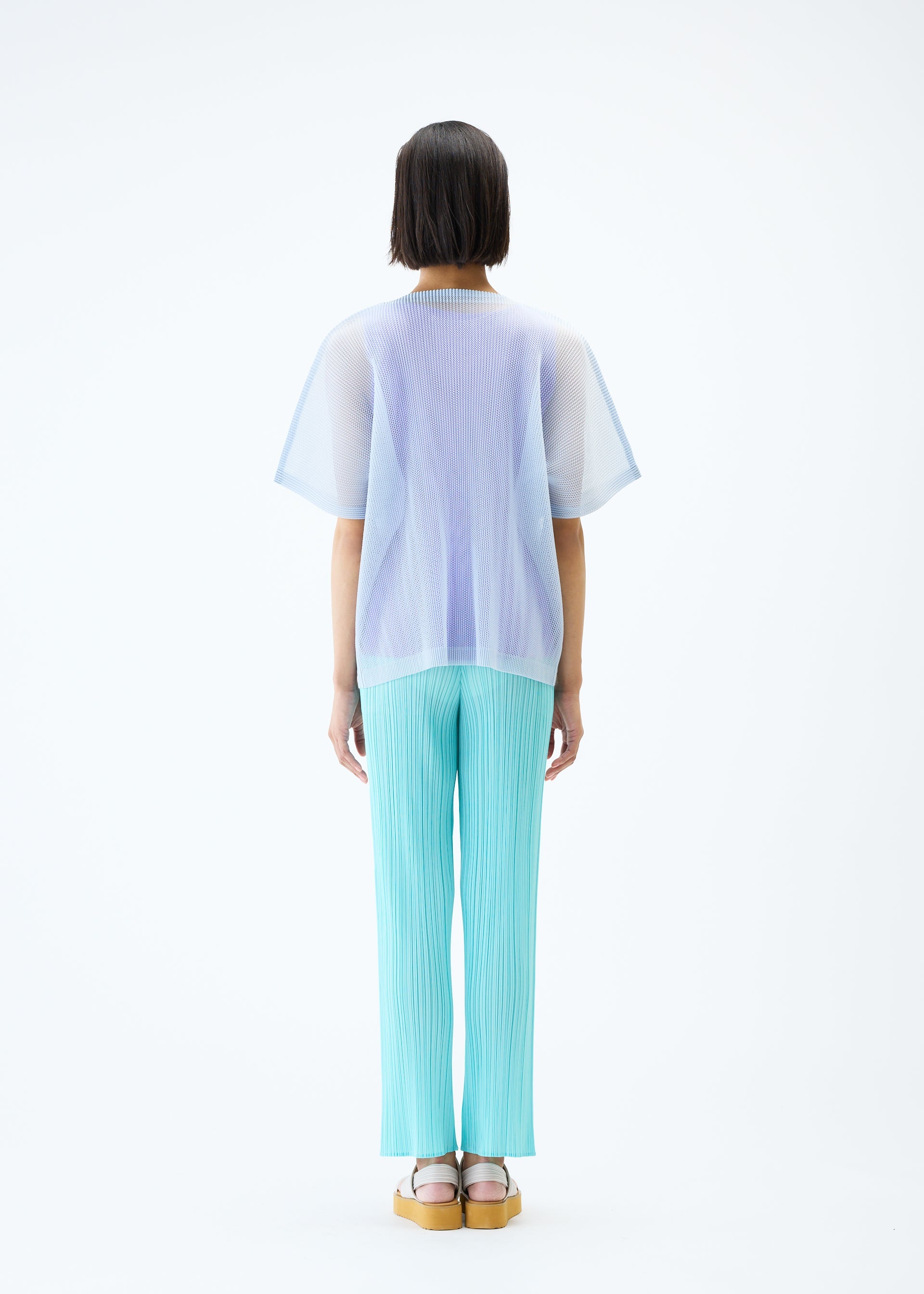A model wears the PLEATS PLEASE ISSEY MIYAKE TATAMI APRIL top.