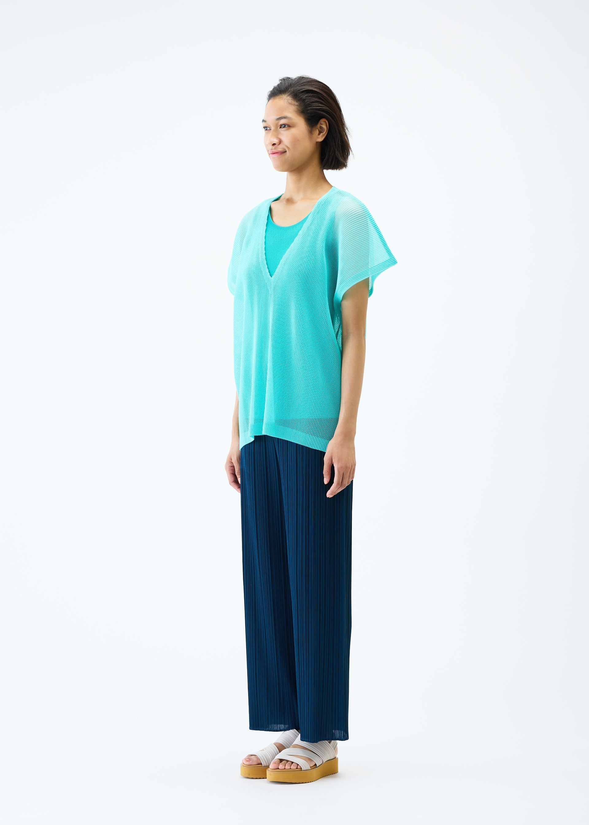 A model wears the PLEATS PLEASE ISSEY MIYAKE TATAMI APRIL top.