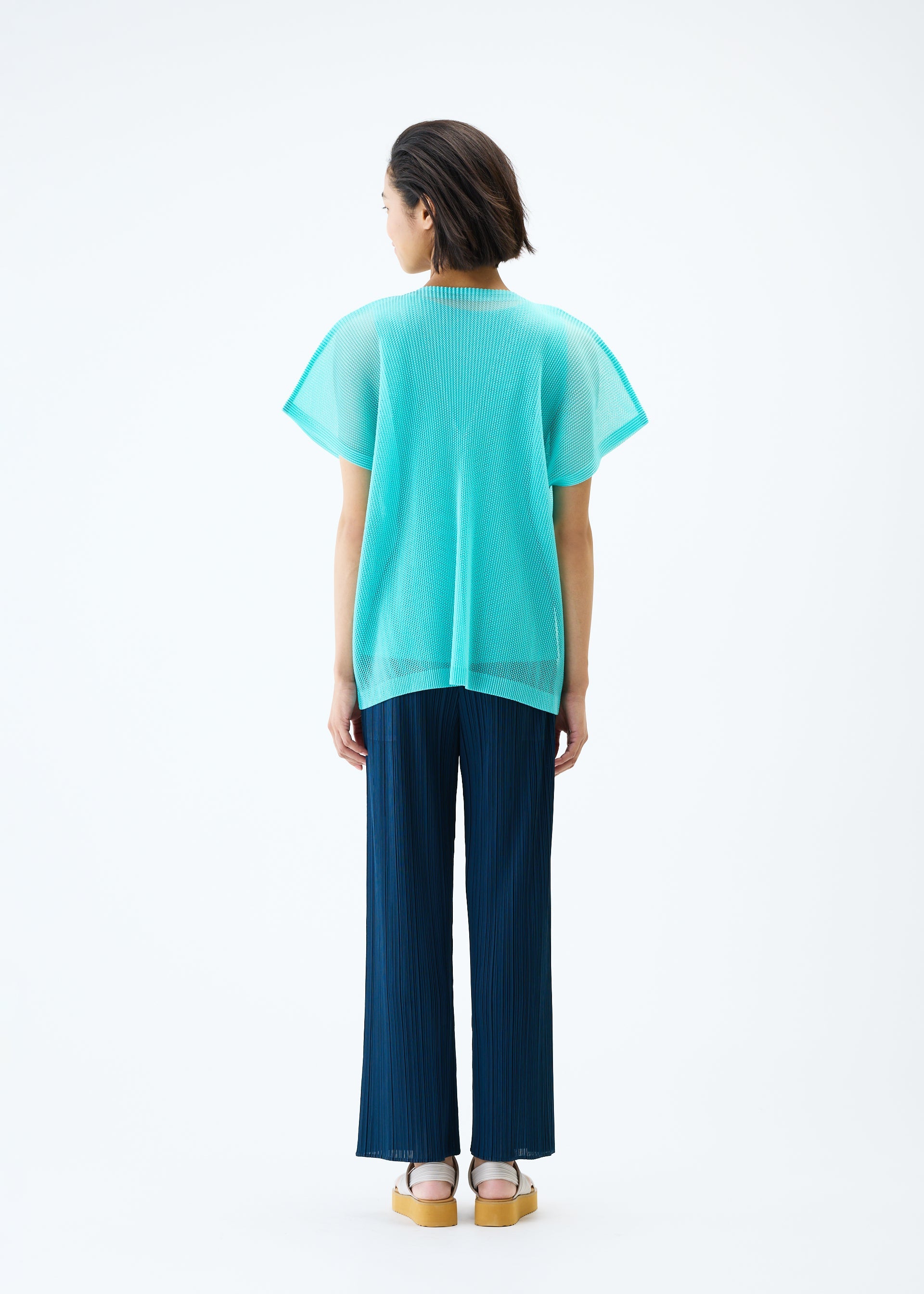 A model wears the PLEATS PLEASE ISSEY MIYAKE TATAMI APRIL top.