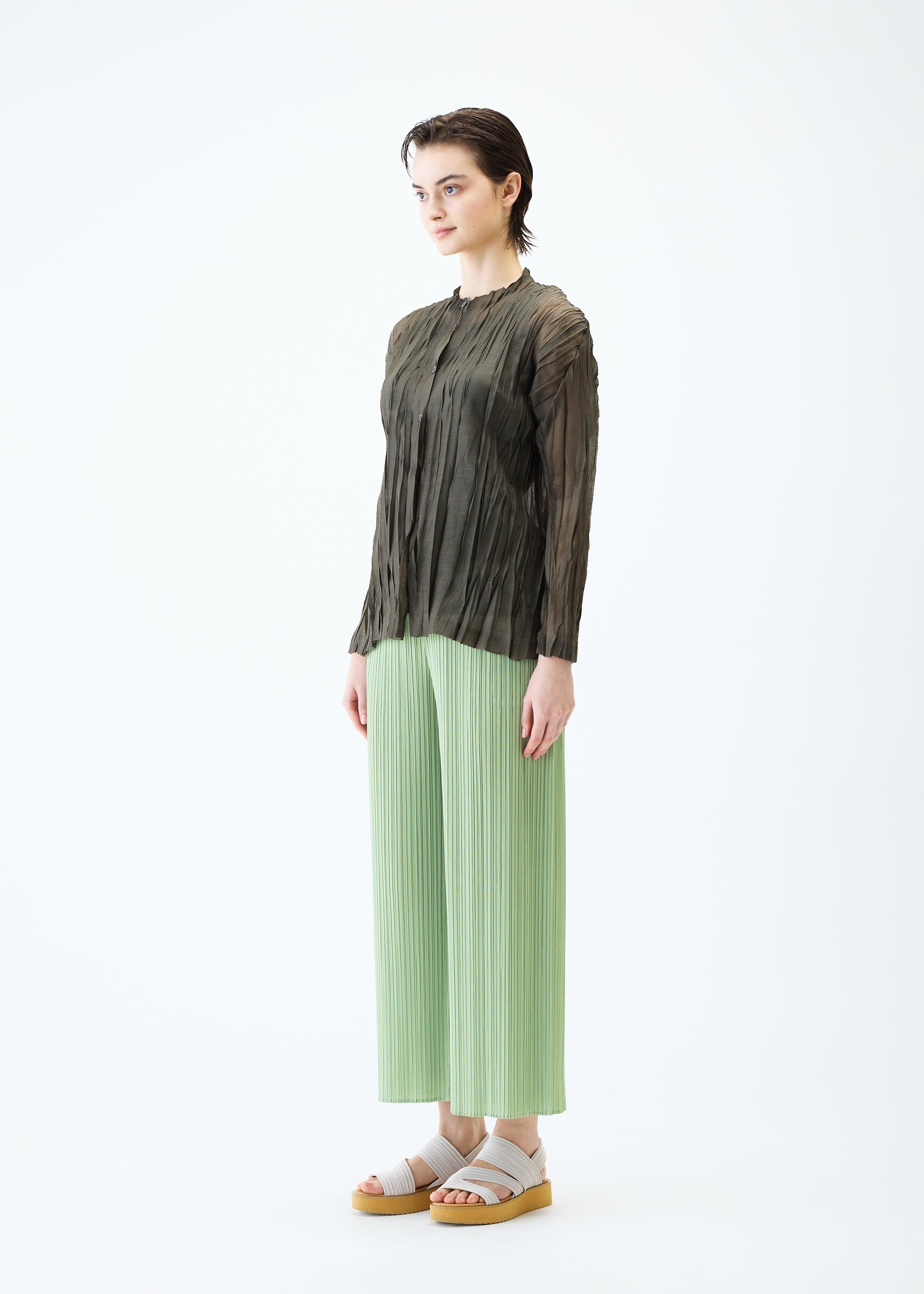 A model wears the PLEATS PLEASE ISSEY MIYAKE SHEER TWIST cardigan.