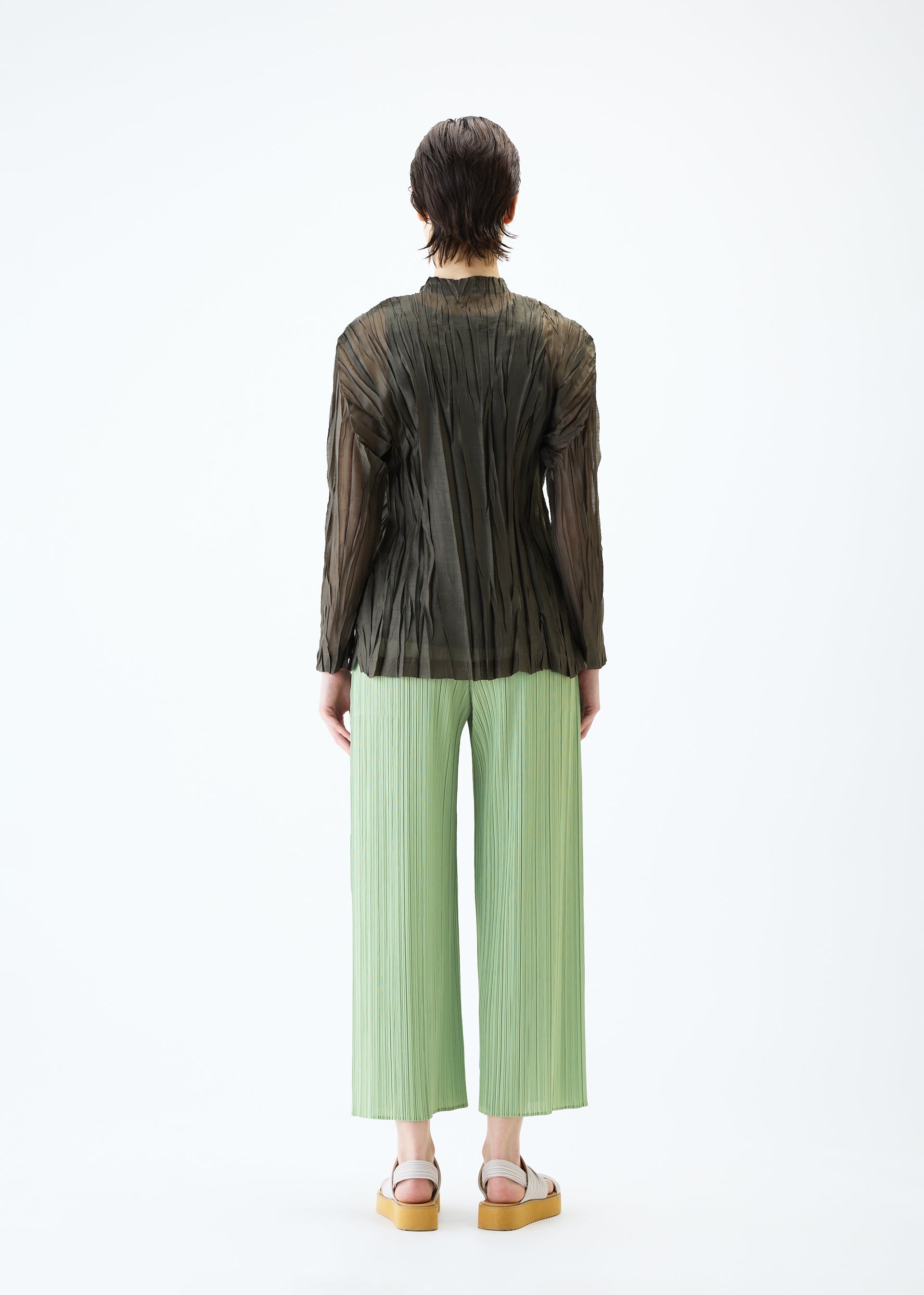 A model wears the PLEATS PLEASE ISSEY MIYAKE SHEER TWIST cardigan.