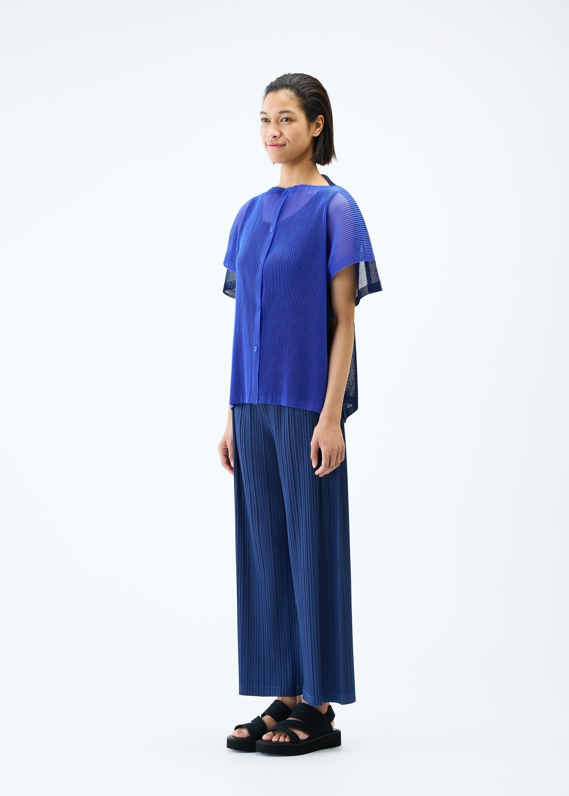 A model wears the PLEATS PLEASE ISSEY MIYAKE SHEER SQUARE cardigan.