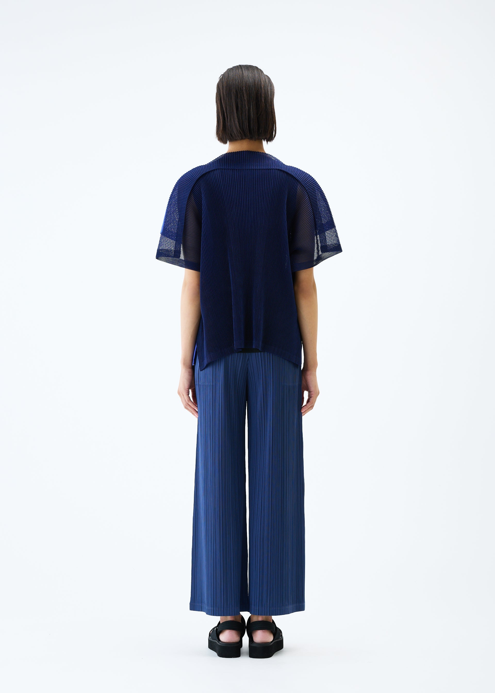 A model wears the PLEATS PLEASE ISSEY MIYAKE SHEER SQUARE cardigan.