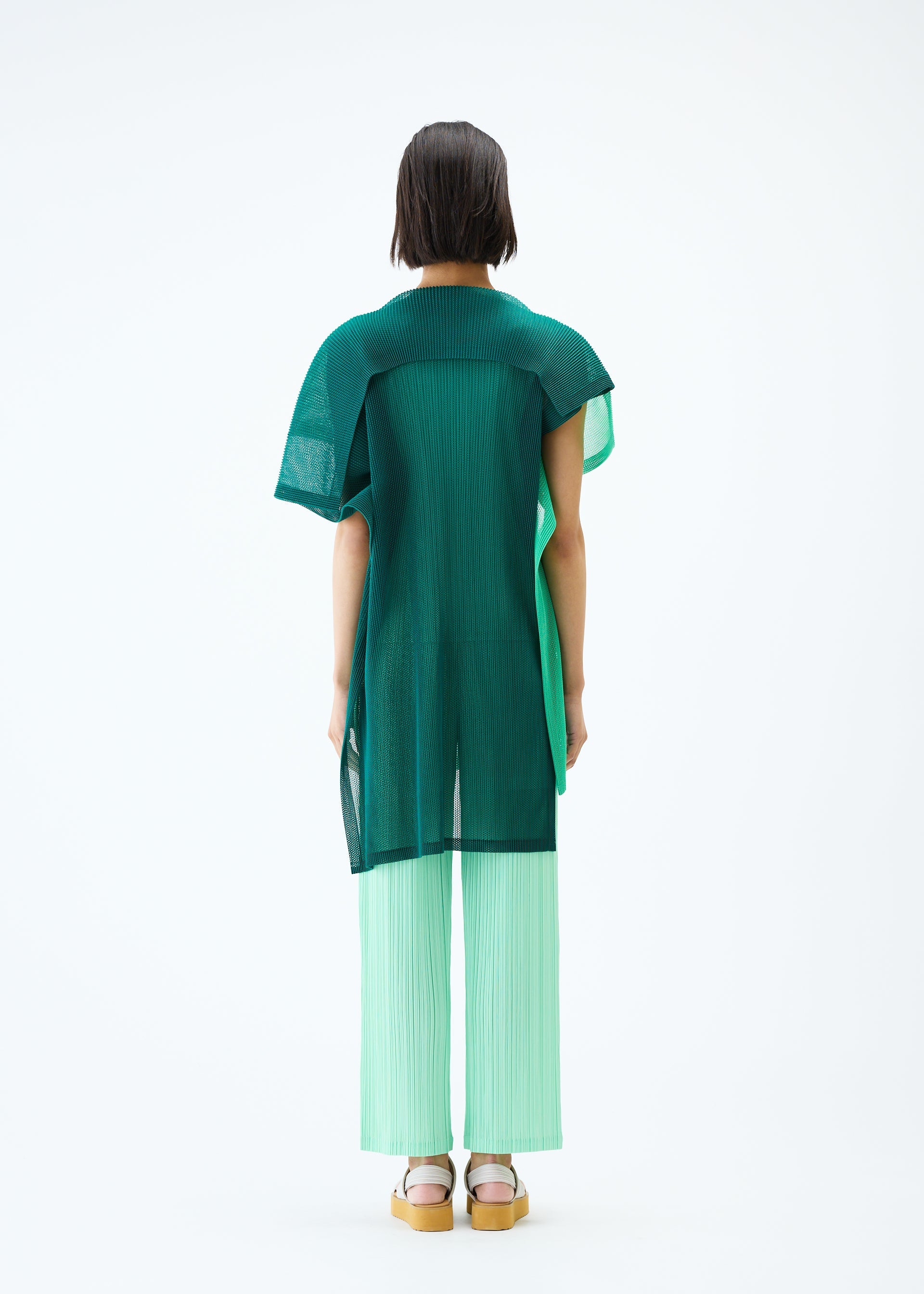 A model wears the PLEATS PLEASE ISSEY MIYAKE SHEER SQUARE tunic.