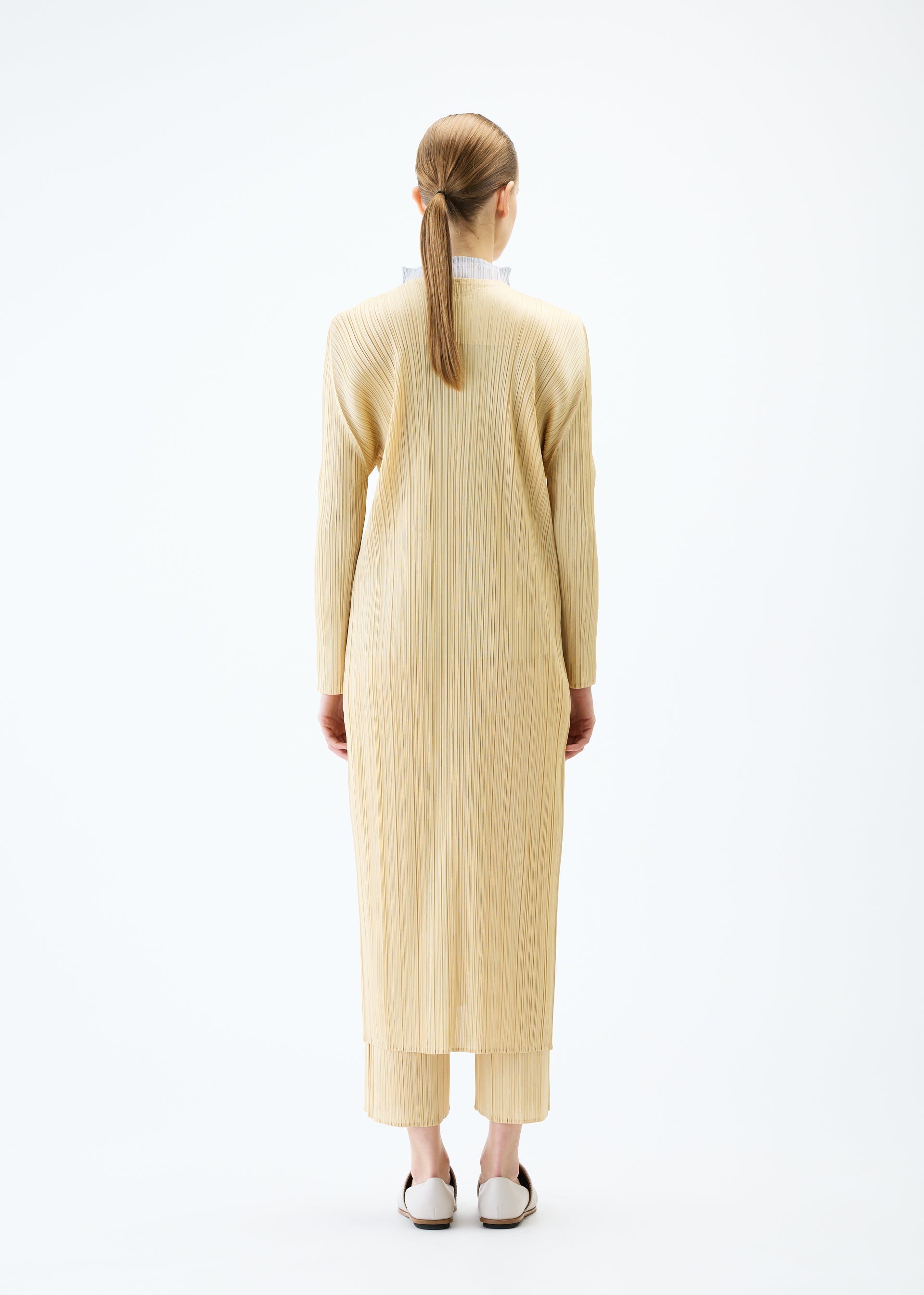 A model wears the PLEATS PLEASE ISSEY MIYAKE MERRY BICOLOR coat.