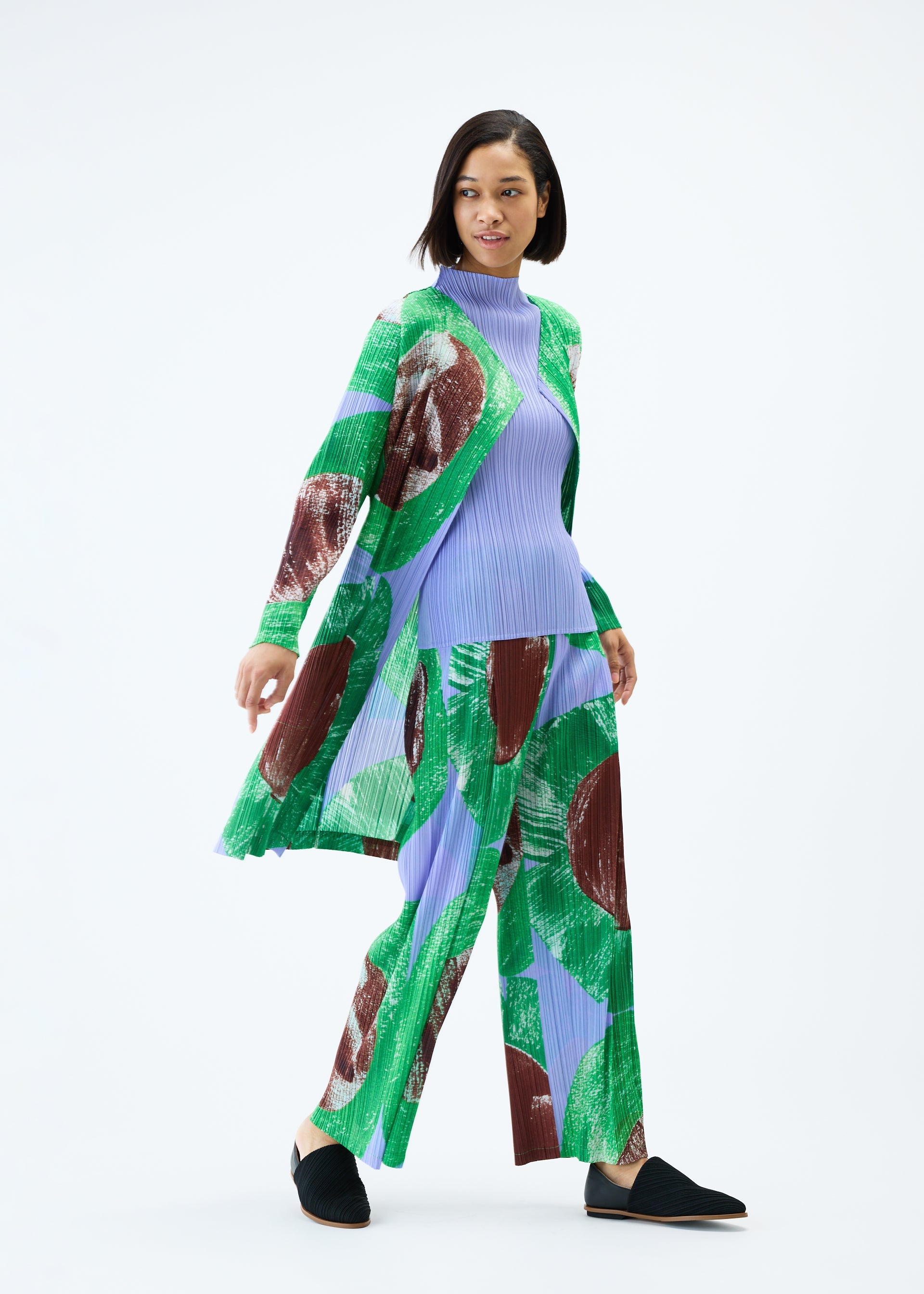 A model wears the PLEATS PLEASE ISSEY MIYAKE BACKLIGHT coat.
