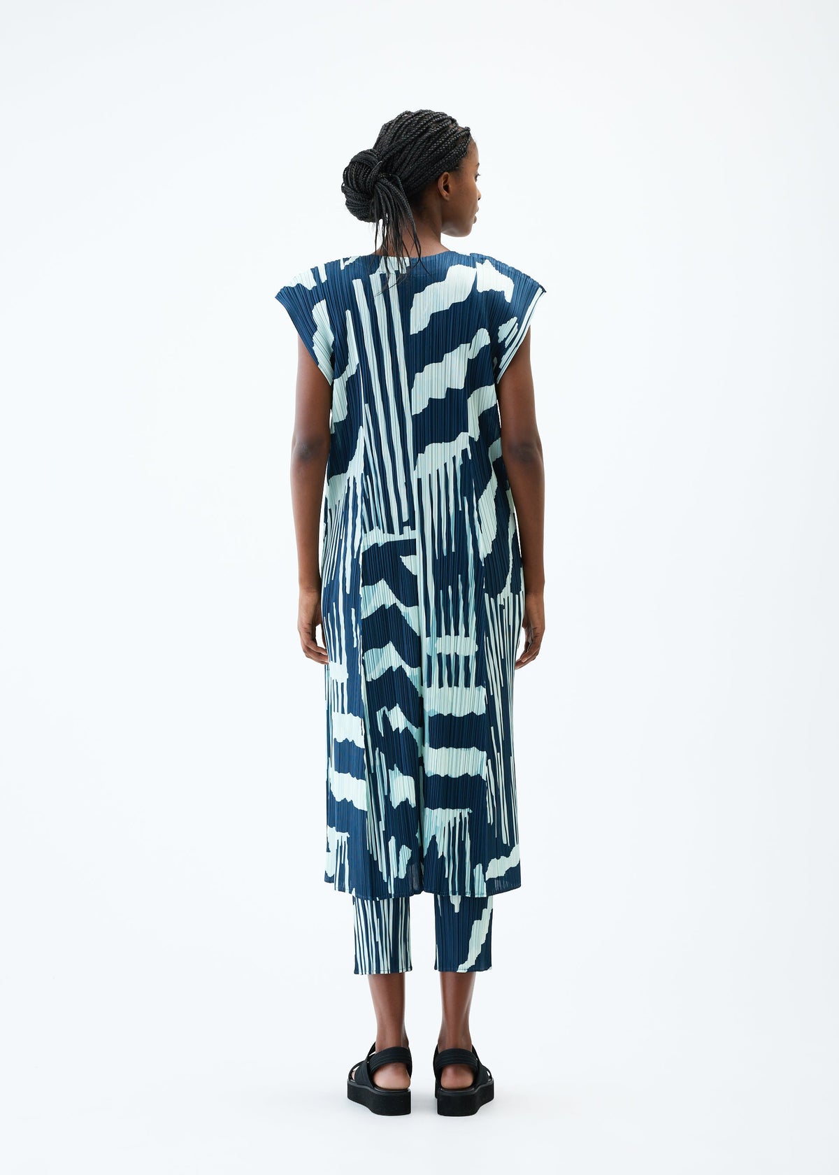 A model wears the PLEATS PLEASE ISSEY MIYAKE REFRACTION vest.
