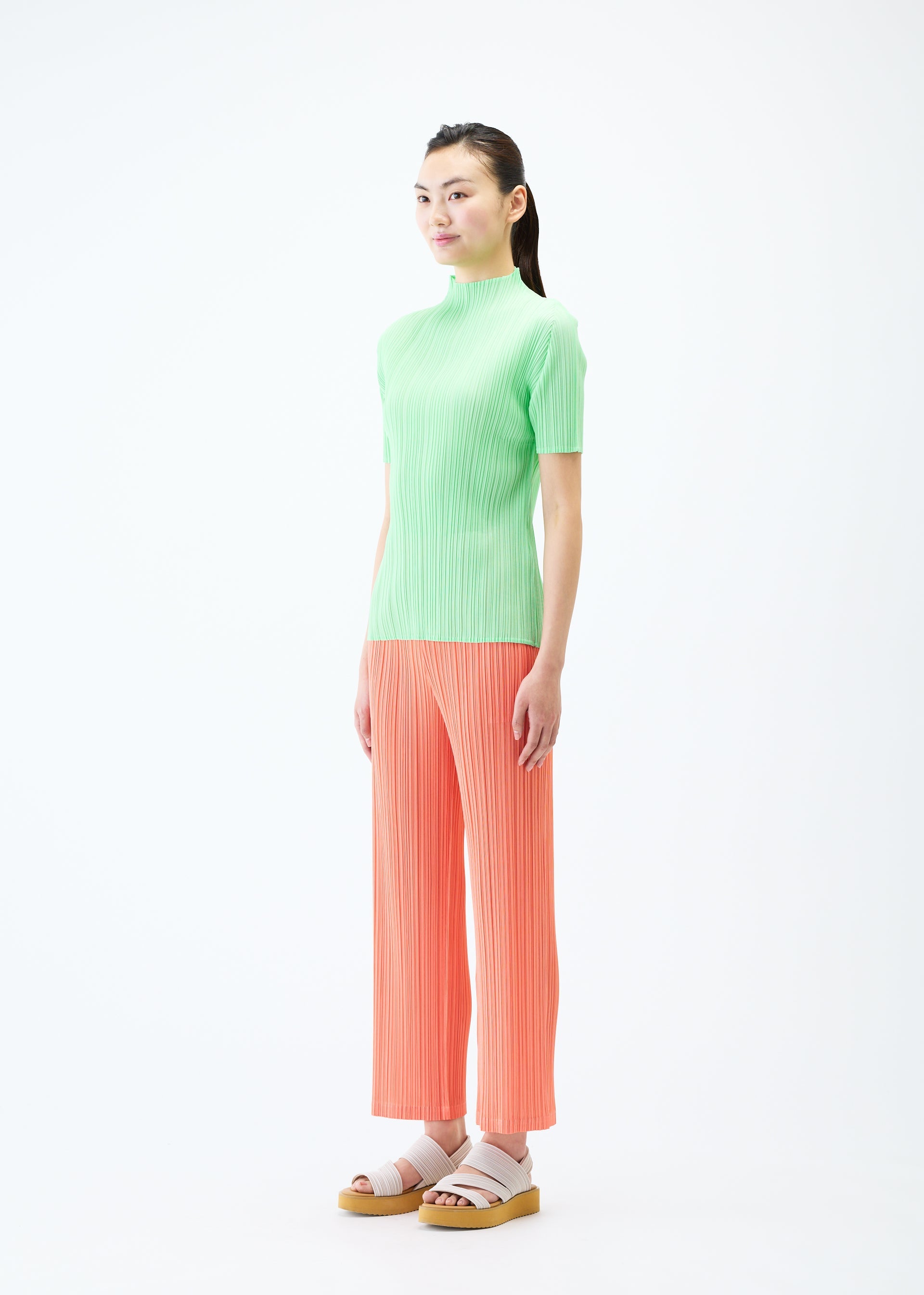A model wears the PLEATS PLEASE ISSEY MIYAKE MONTHLY COLORS MAY trousers.