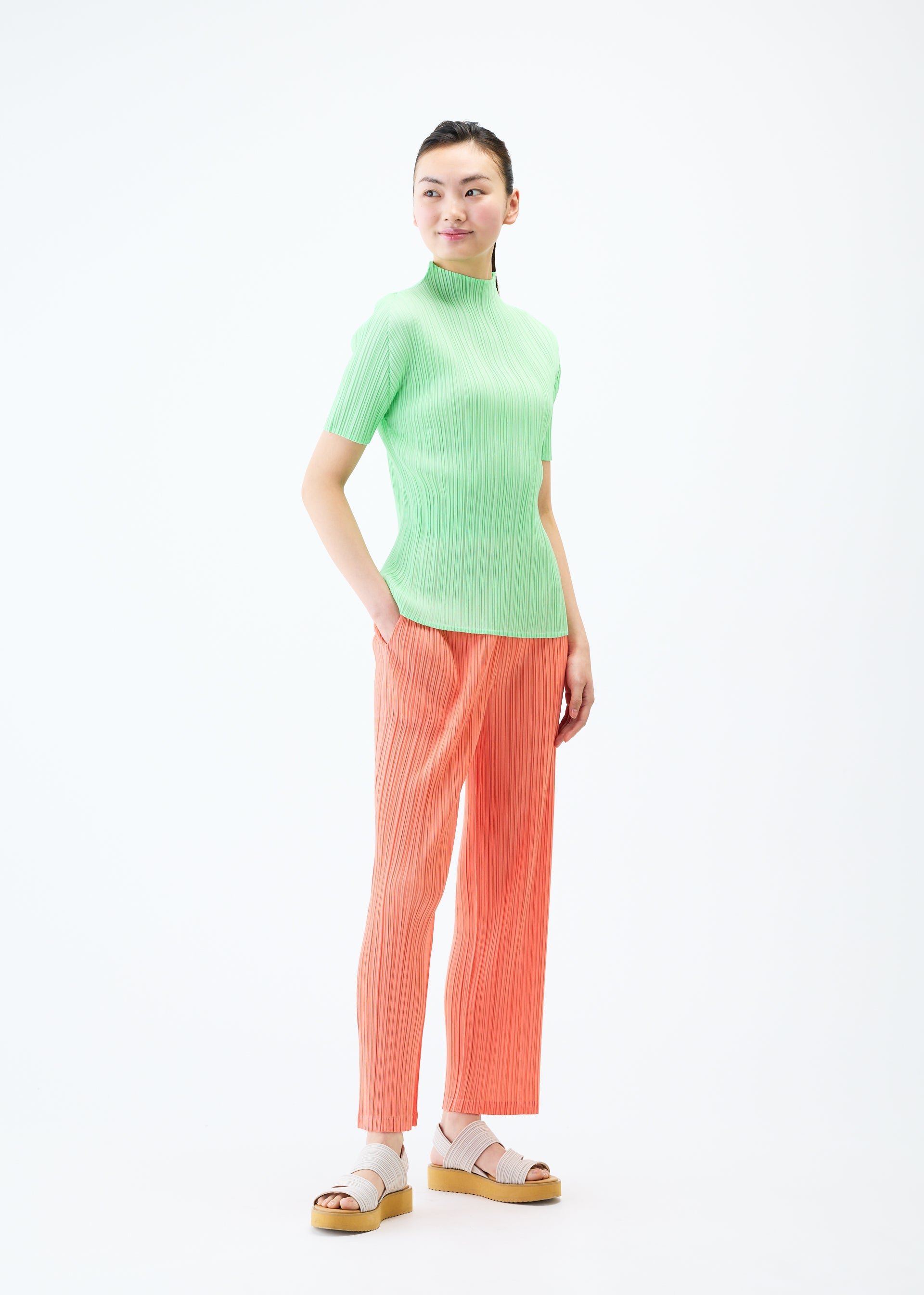 A model wears the PLEATS PLEASE ISSEY MIYAKE MONTHLY COLORS MAY trousers.