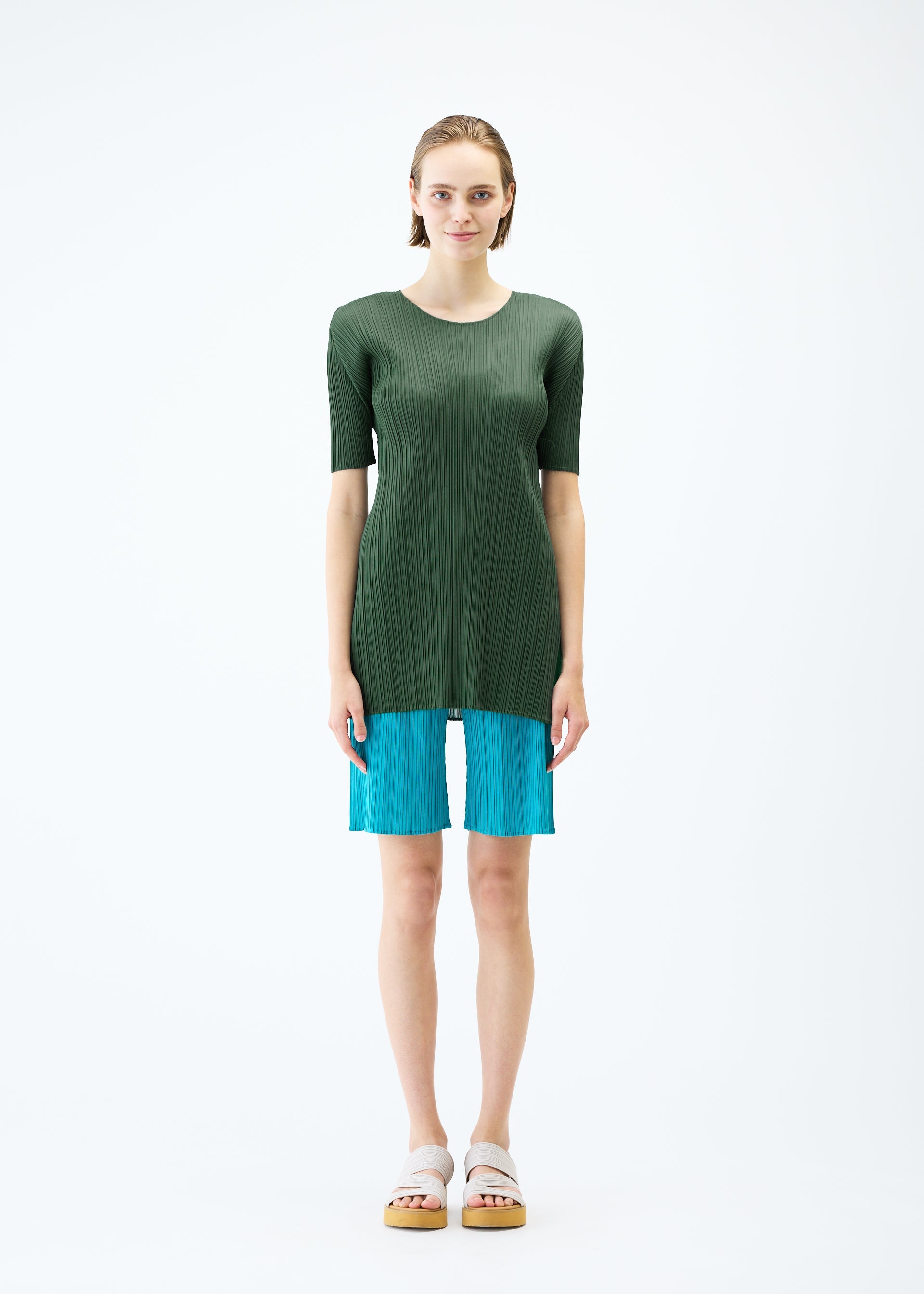 A model wears the PLEATS PLEASE ISSEY MIYAKE MONTHLY COLORS : JUNE trousers.