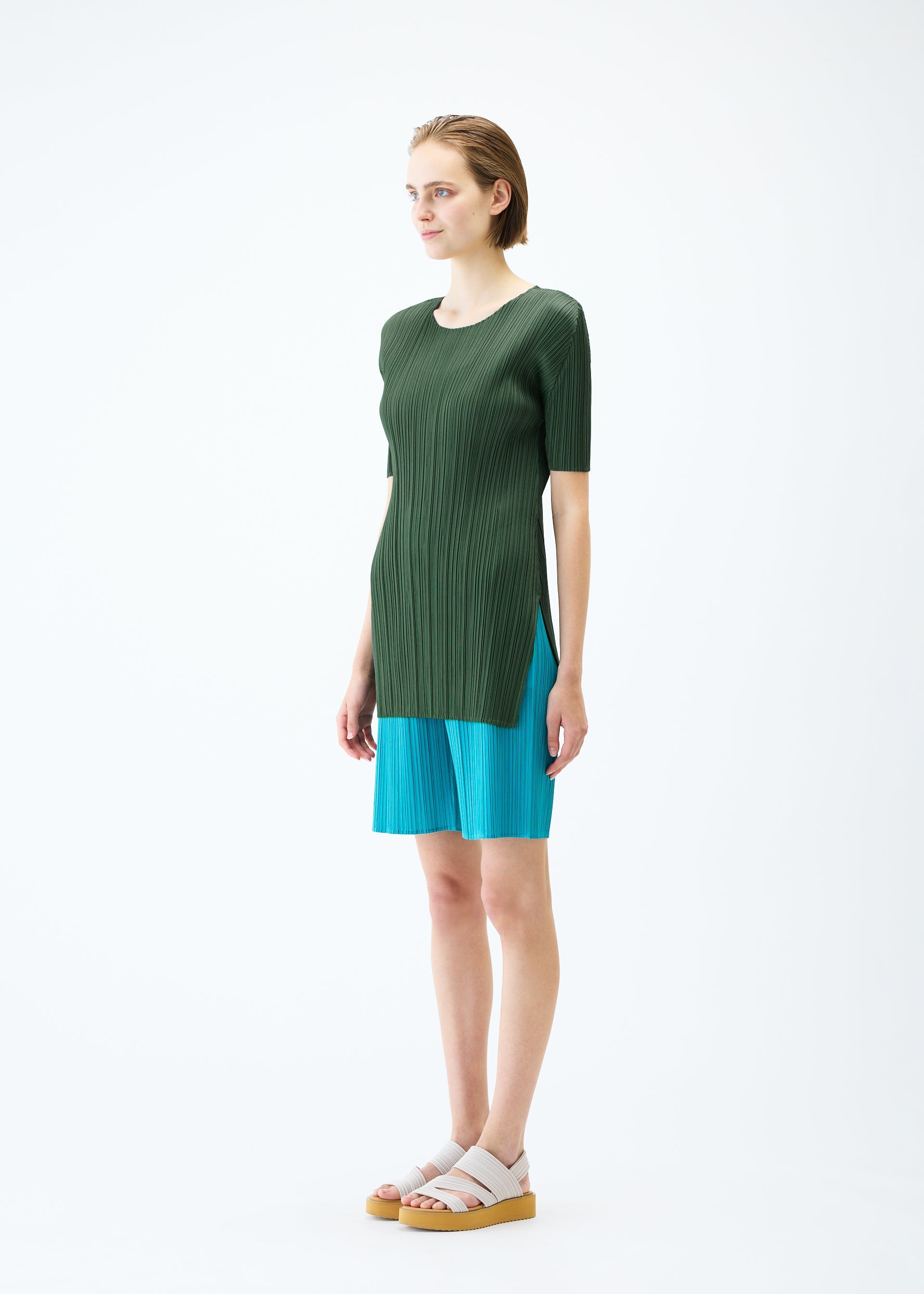 A model wears the PLEATS PLEASE ISSEY MIYAKE MONTHLY COLORS : JUNE trousers.