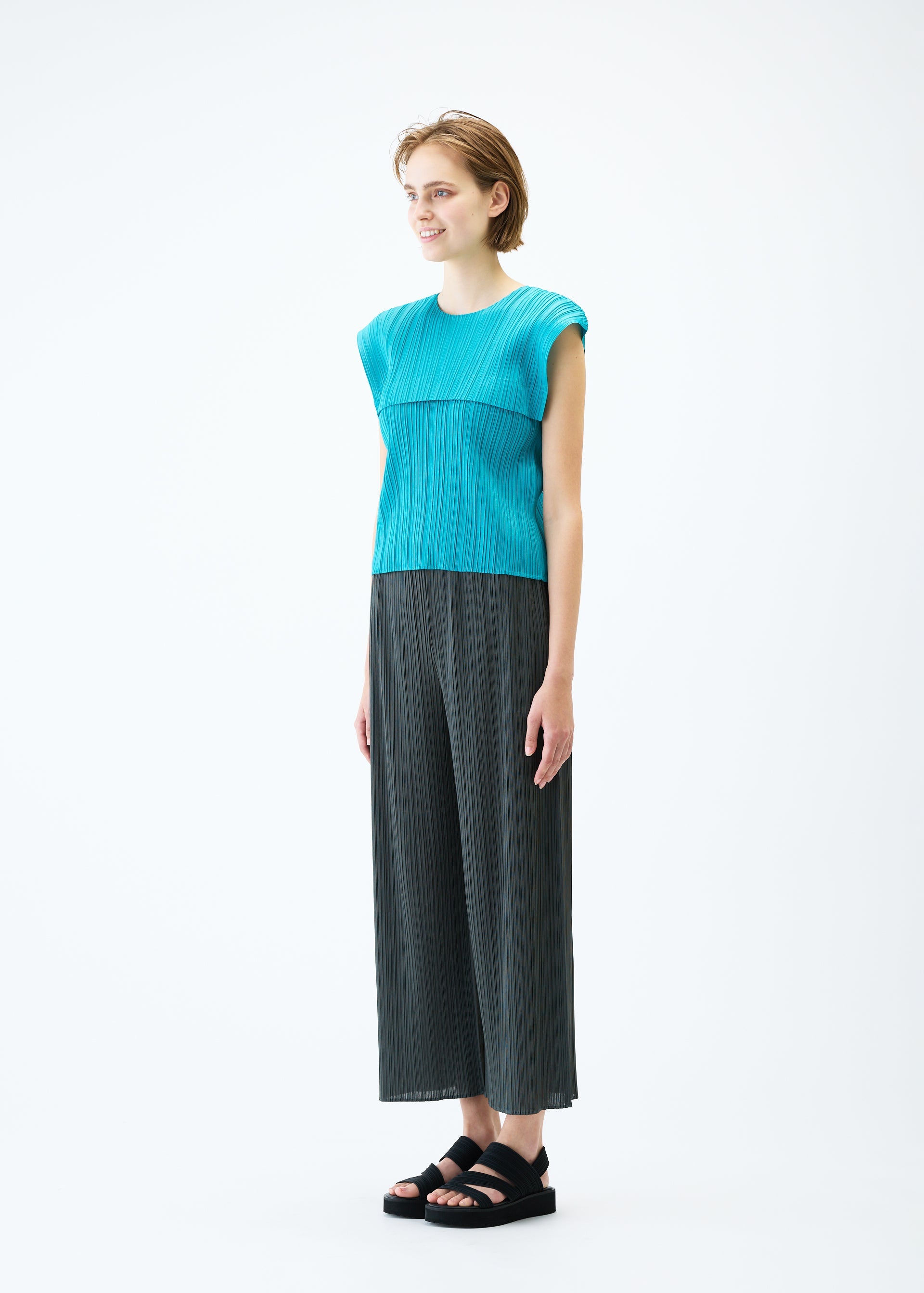A model wears the PLEATS PLEASE ISSEY MIYAKE MONTHLY COLORS : JUNE trousers.