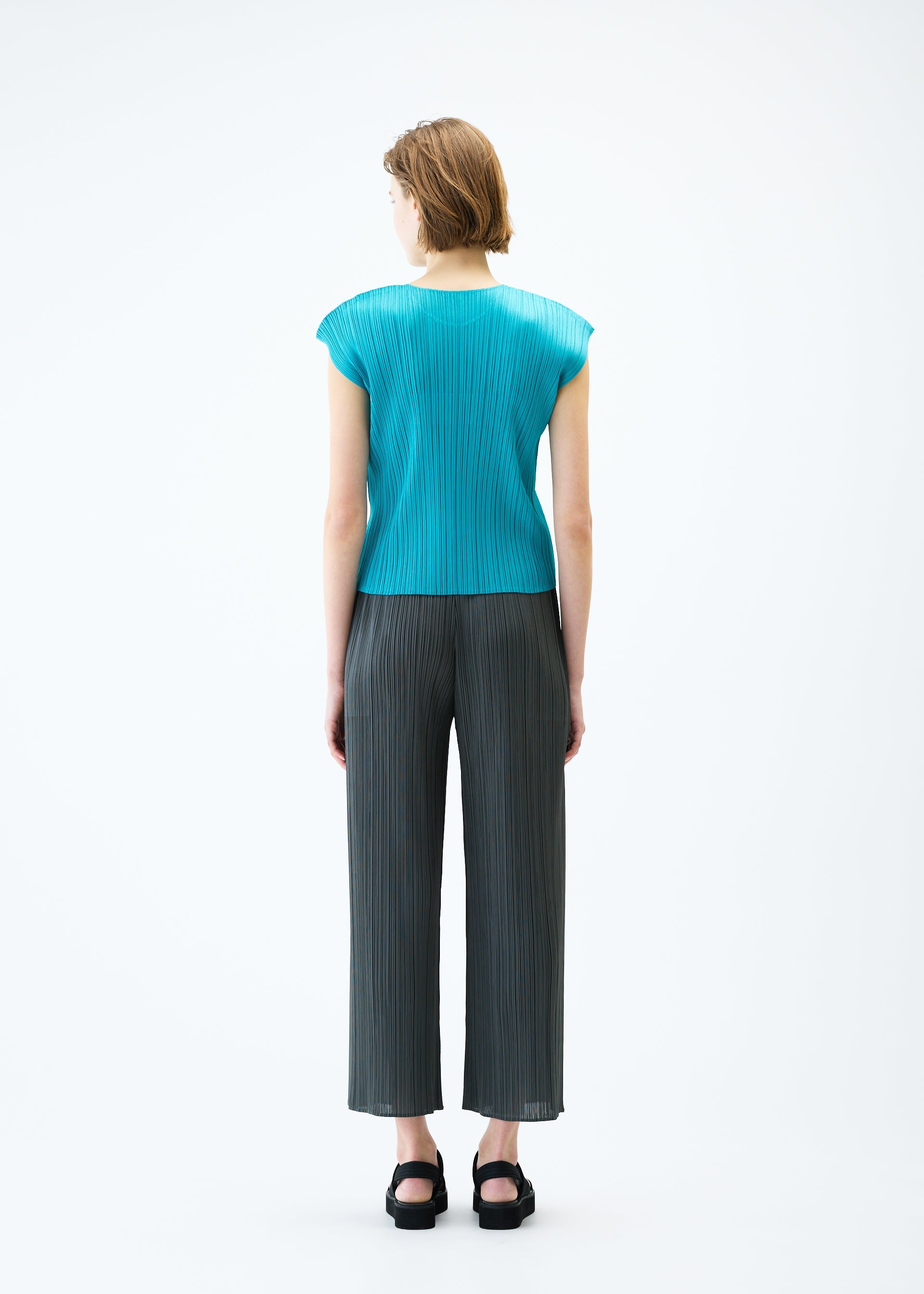 A model wears the PLEATS PLEASE ISSEY MIYAKE MONTHLY COLORS : JUNE trousers.