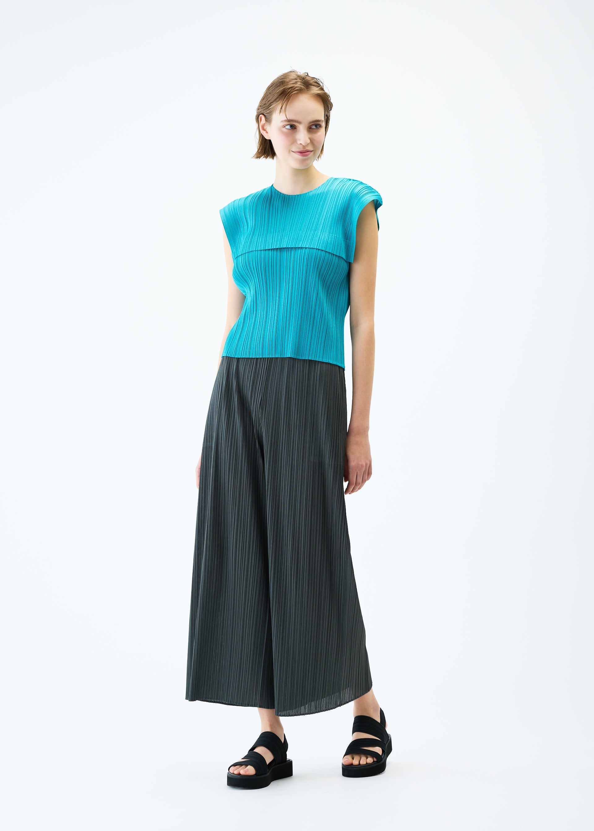 A model wears the PLEATS PLEASE ISSEY MIYAKE MONTHLY COLORS : JUNE trousers.