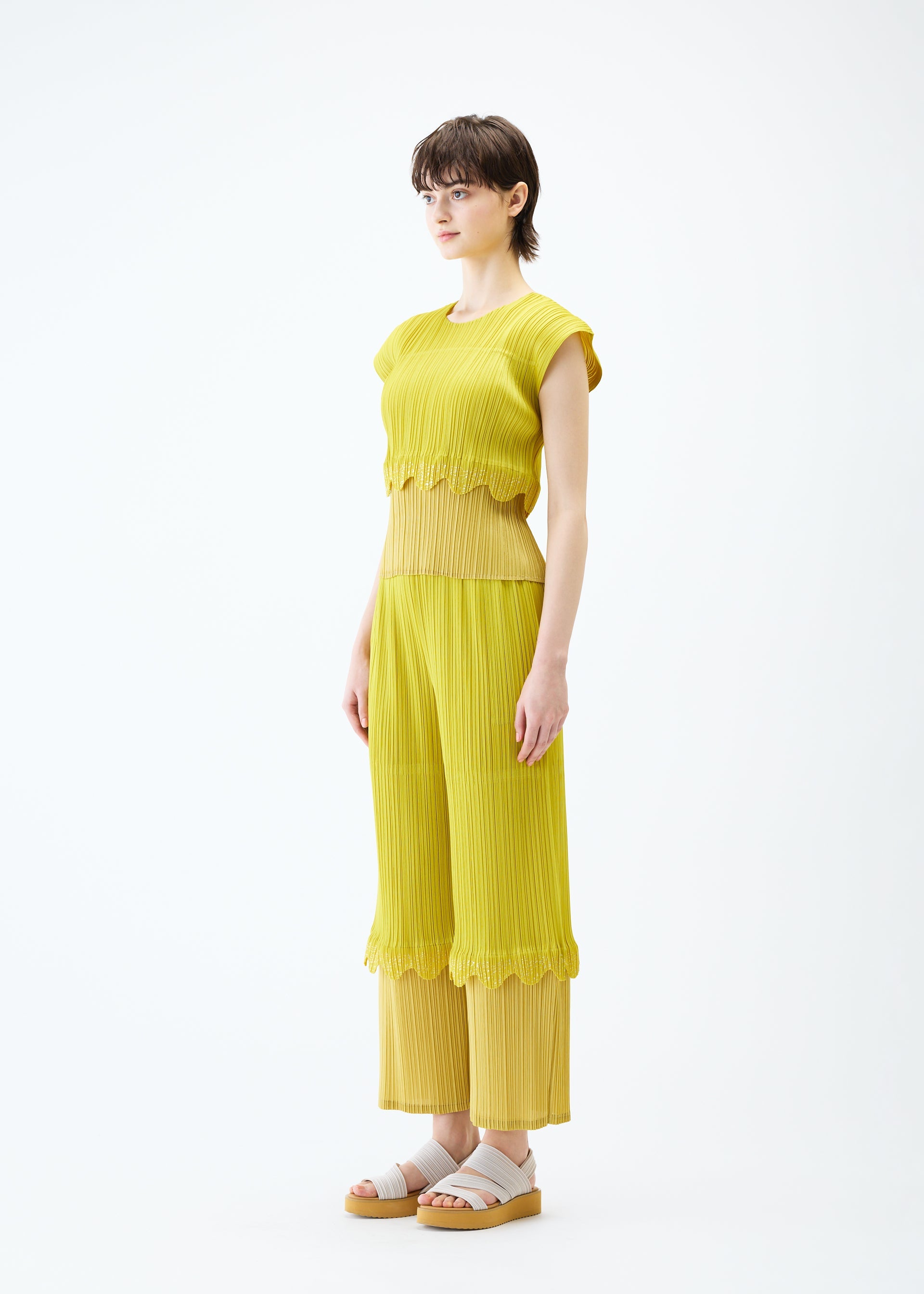 A model wears the PLEATS PLEASE ISSEY MIYAKE TWINKLE trousers.