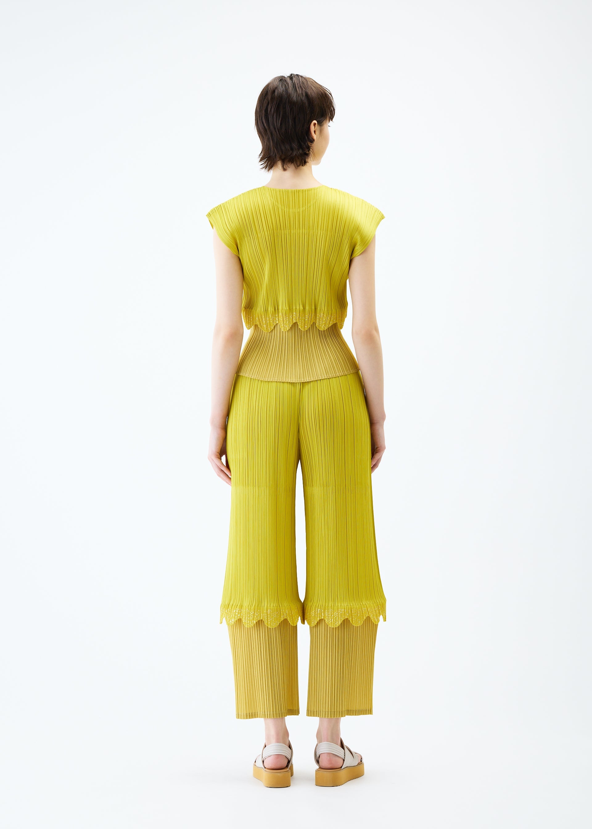A model wears the PLEATS PLEASE ISSEY MIYAKE TWINKLE trousers.
