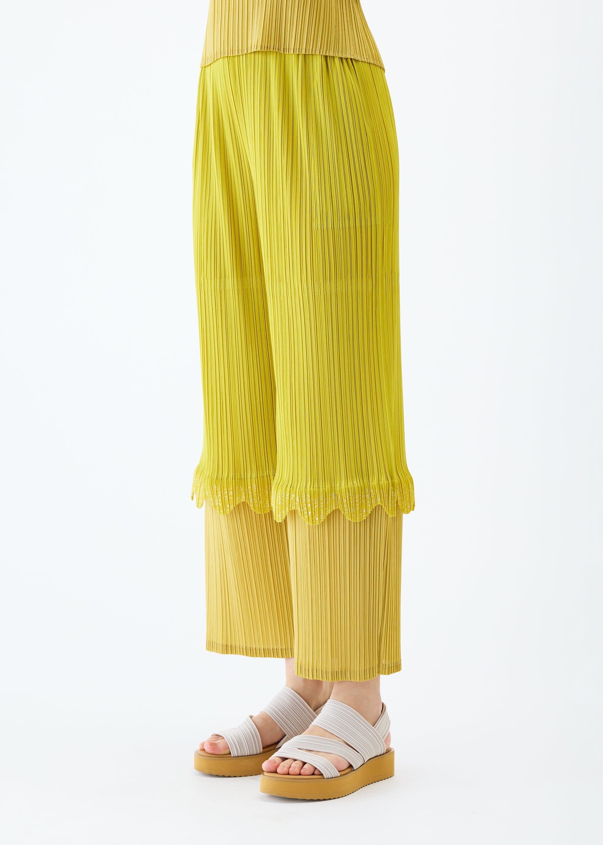 A model wears the PLEATS PLEASE ISSEY MIYAKE TWINKLE trousers.