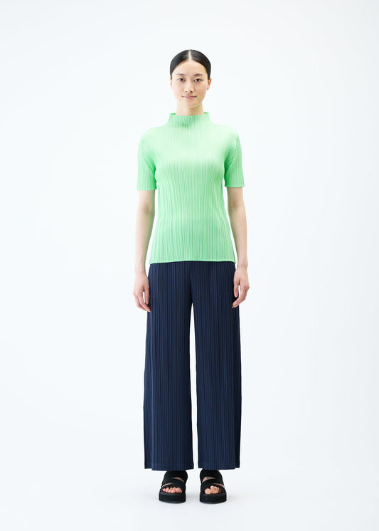 A model wears the PLEATS PLEASE ISSEY MIYAKE LOOP BOTTOMS trousers.