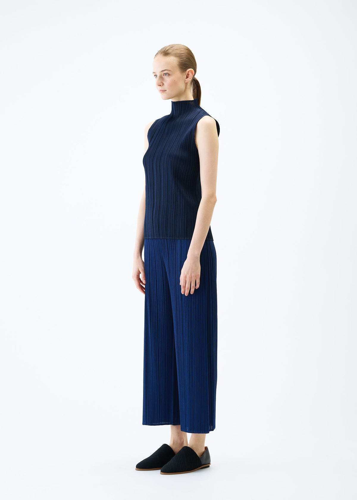 A model wears the PLEATS PLEASE ISSEY MIYAKE MERRY BICOLOR trousers.