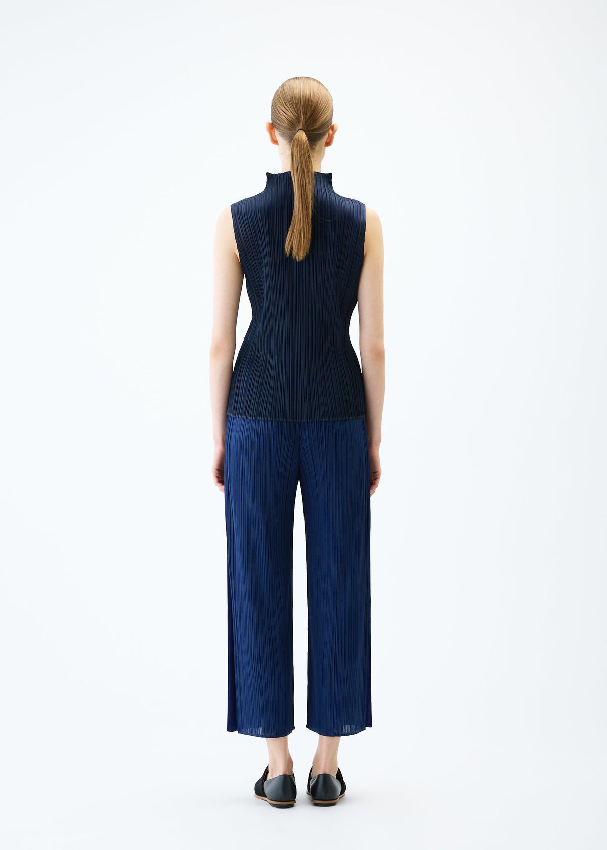A model wears the PLEATS PLEASE ISSEY MIYAKE MERRY BICOLOR trousers.