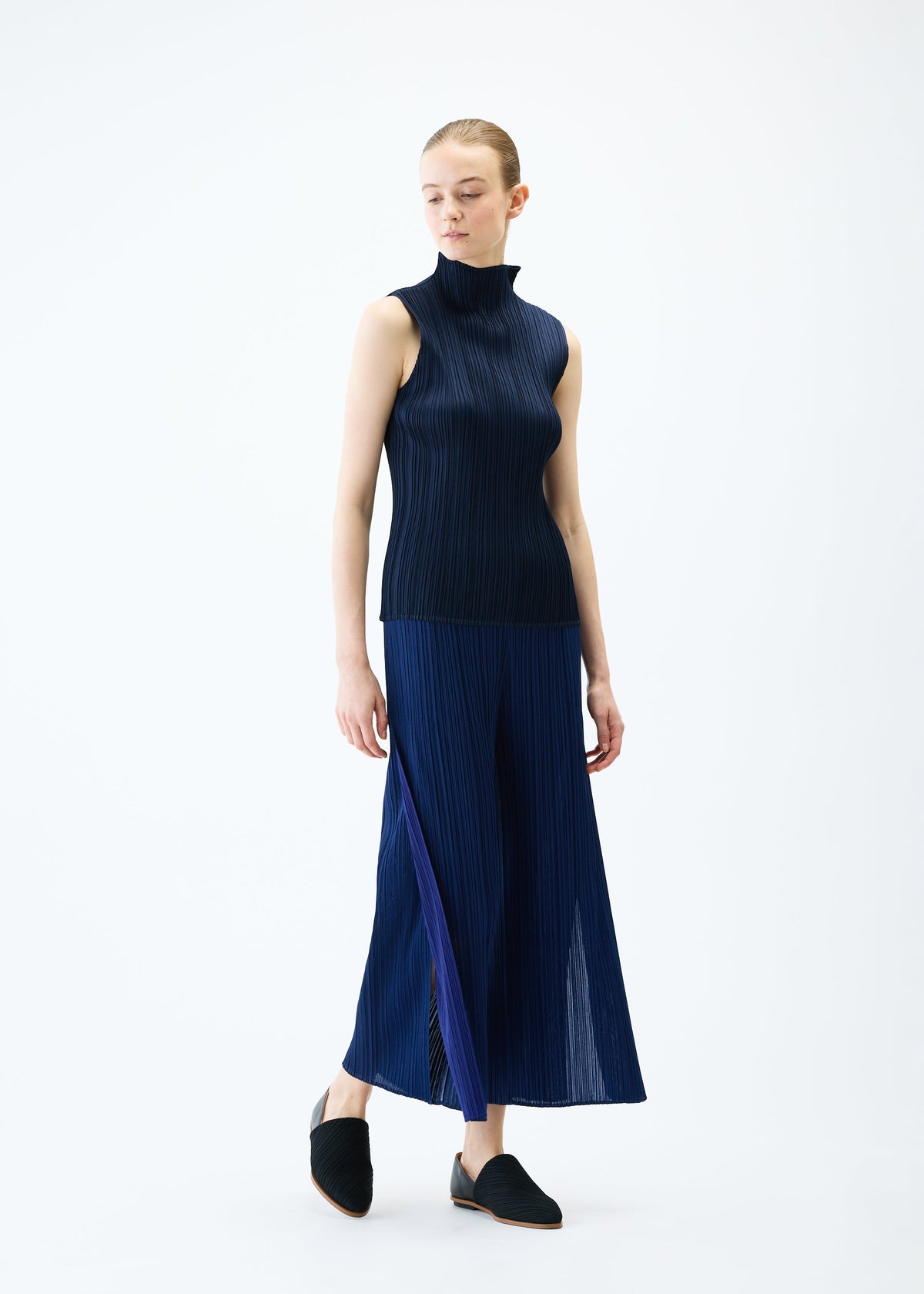 A model wears the PLEATS PLEASE ISSEY MIYAKE MERRY BICOLOR trousers.