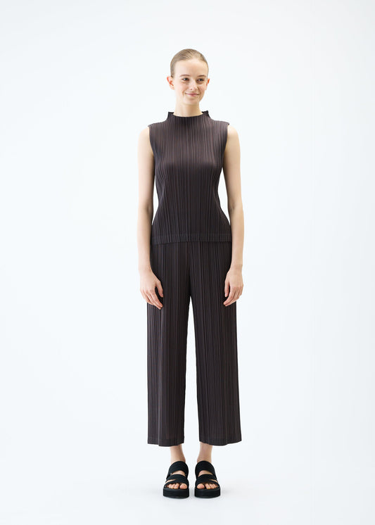 A model wears the PLEATS PLEASE ISSEY MIYAKE RAMIE PLEATS trousers.