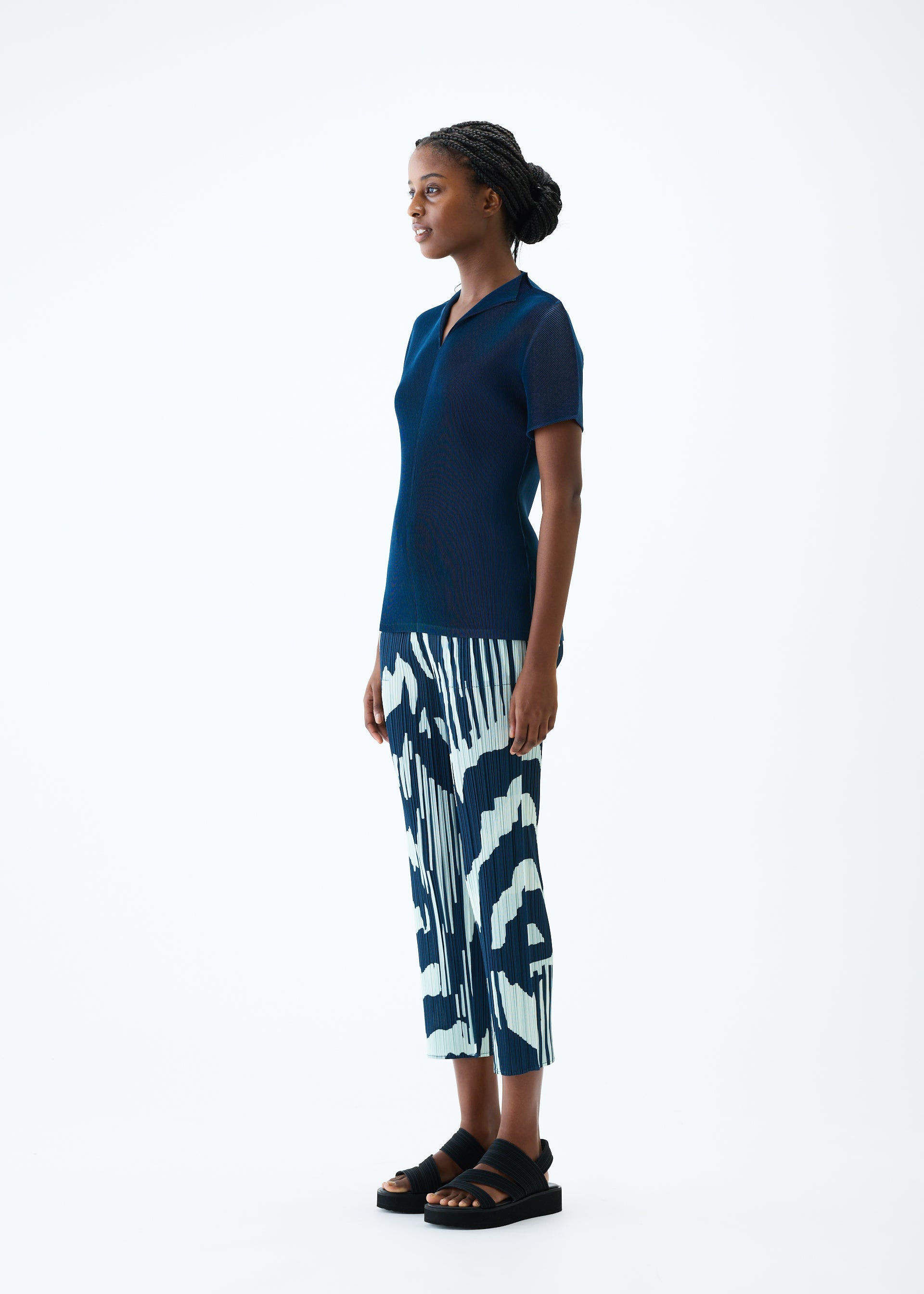 A model wears the PLEATS PLEASE ISSEY MIYAKE REFRACTION trousers.