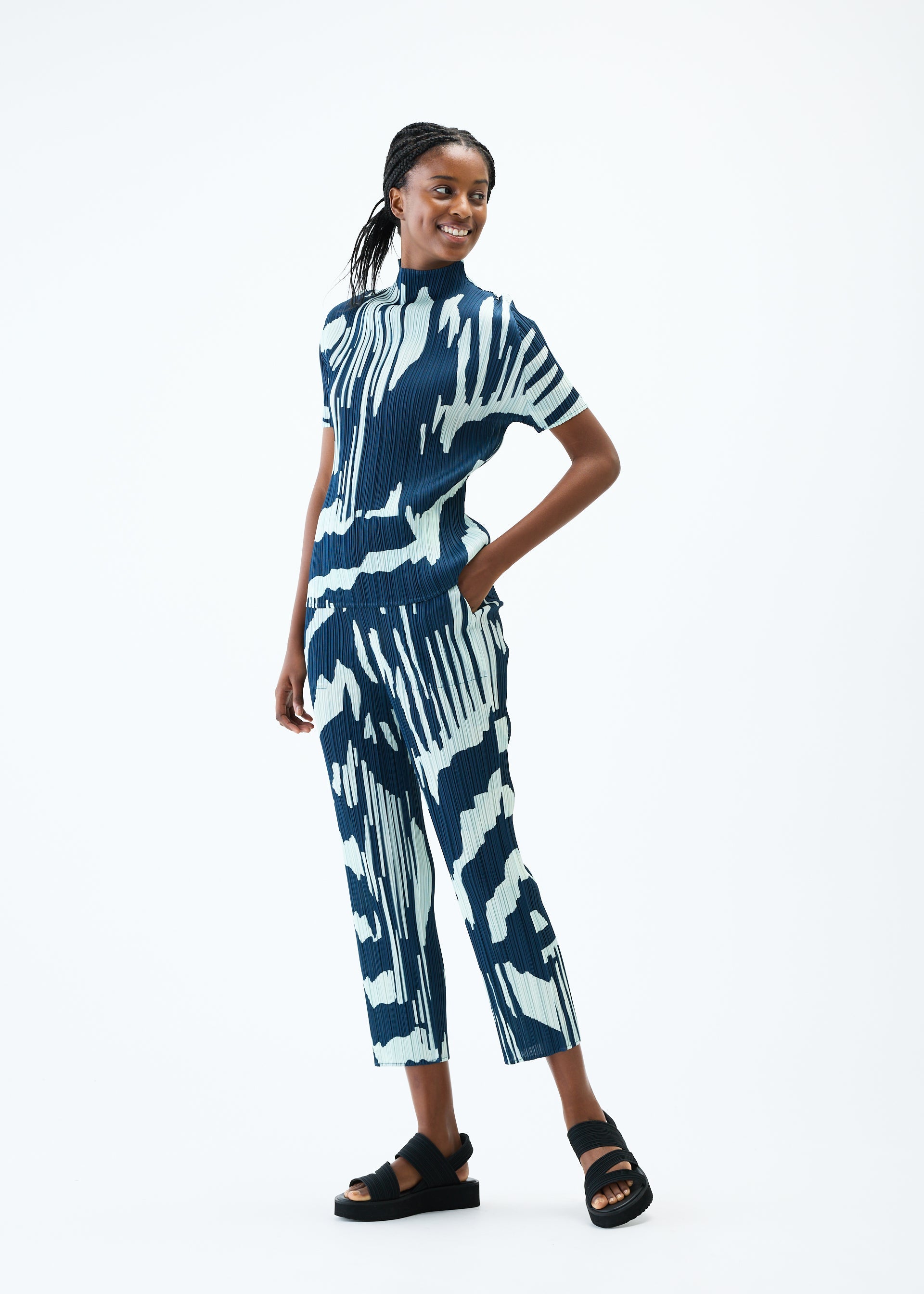 A model wears the PLEATS PLEASE ISSEY MIYAKE REFRACTION trousers.