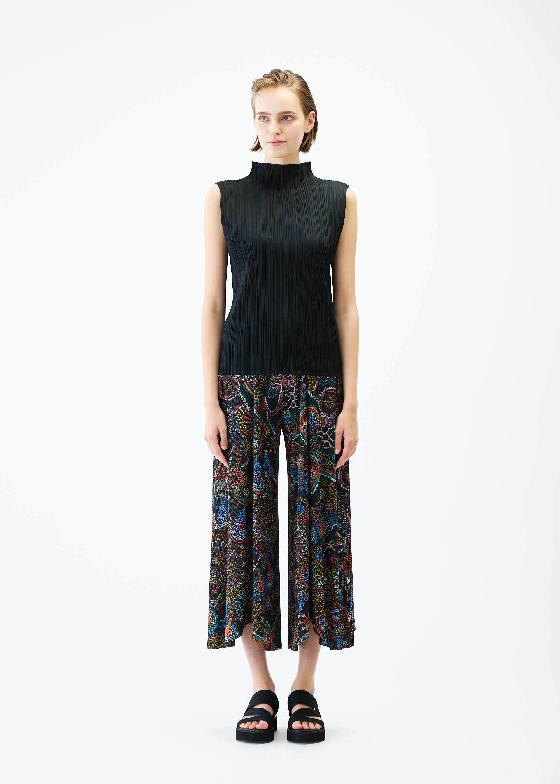 A model wears the PLEATS PLEASE ISSEY MIYAKE LIGHT FESTIVAL trousers.