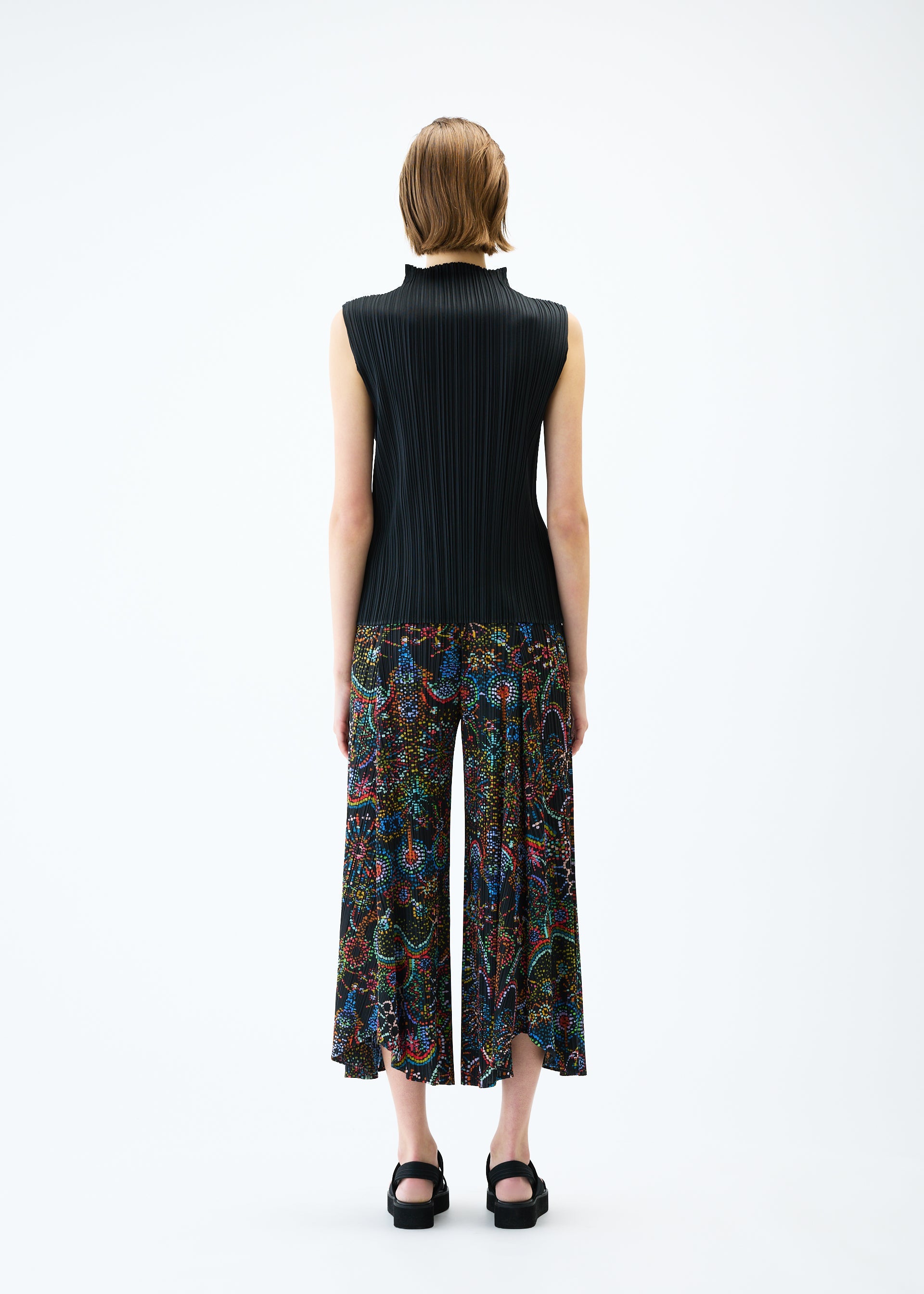 A model wears the PLEATS PLEASE ISSEY MIYAKE LIGHT FESTIVAL trousers.