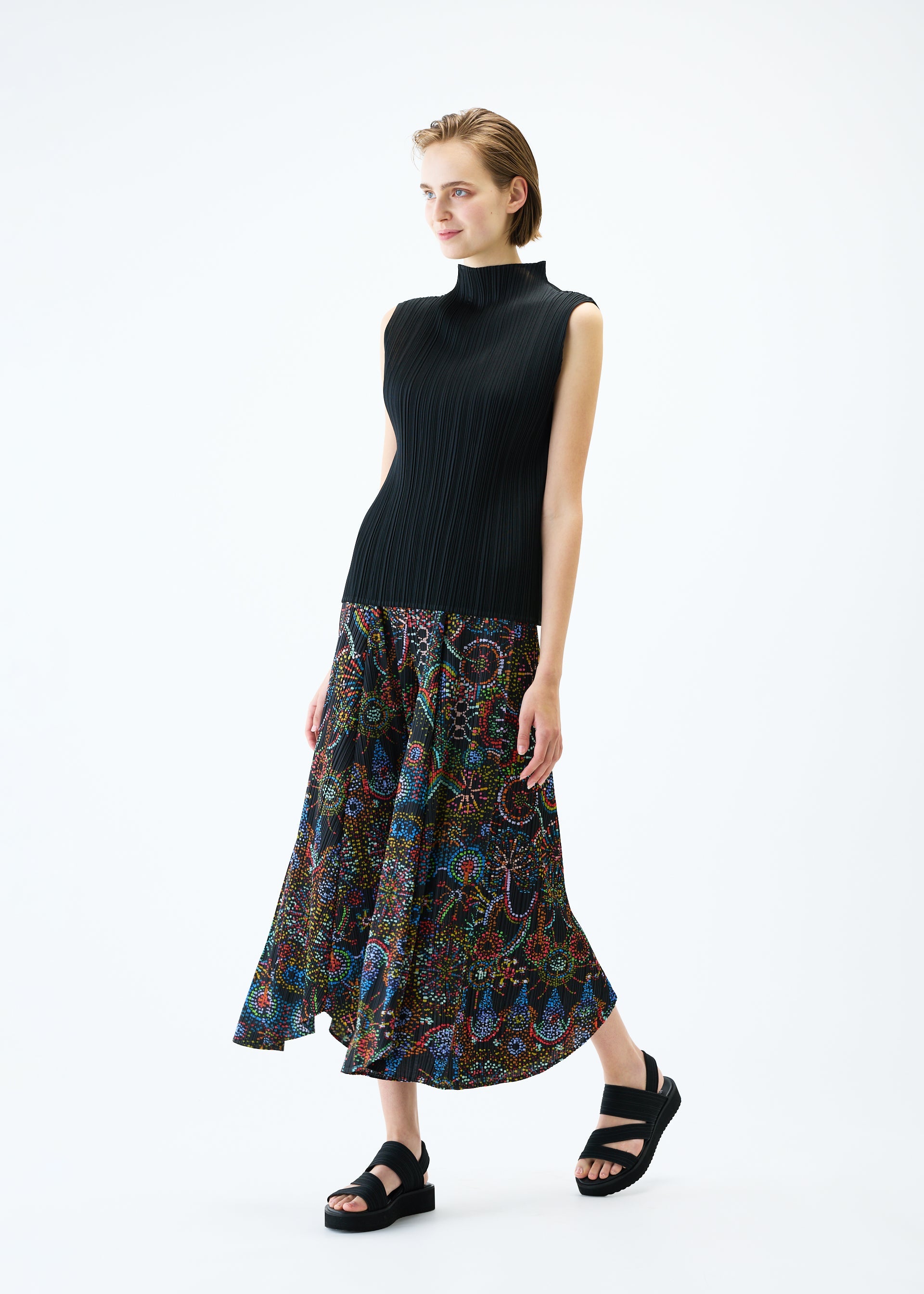 A model wears the PLEATS PLEASE ISSEY MIYAKE LIGHT FESTIVAL trousers.