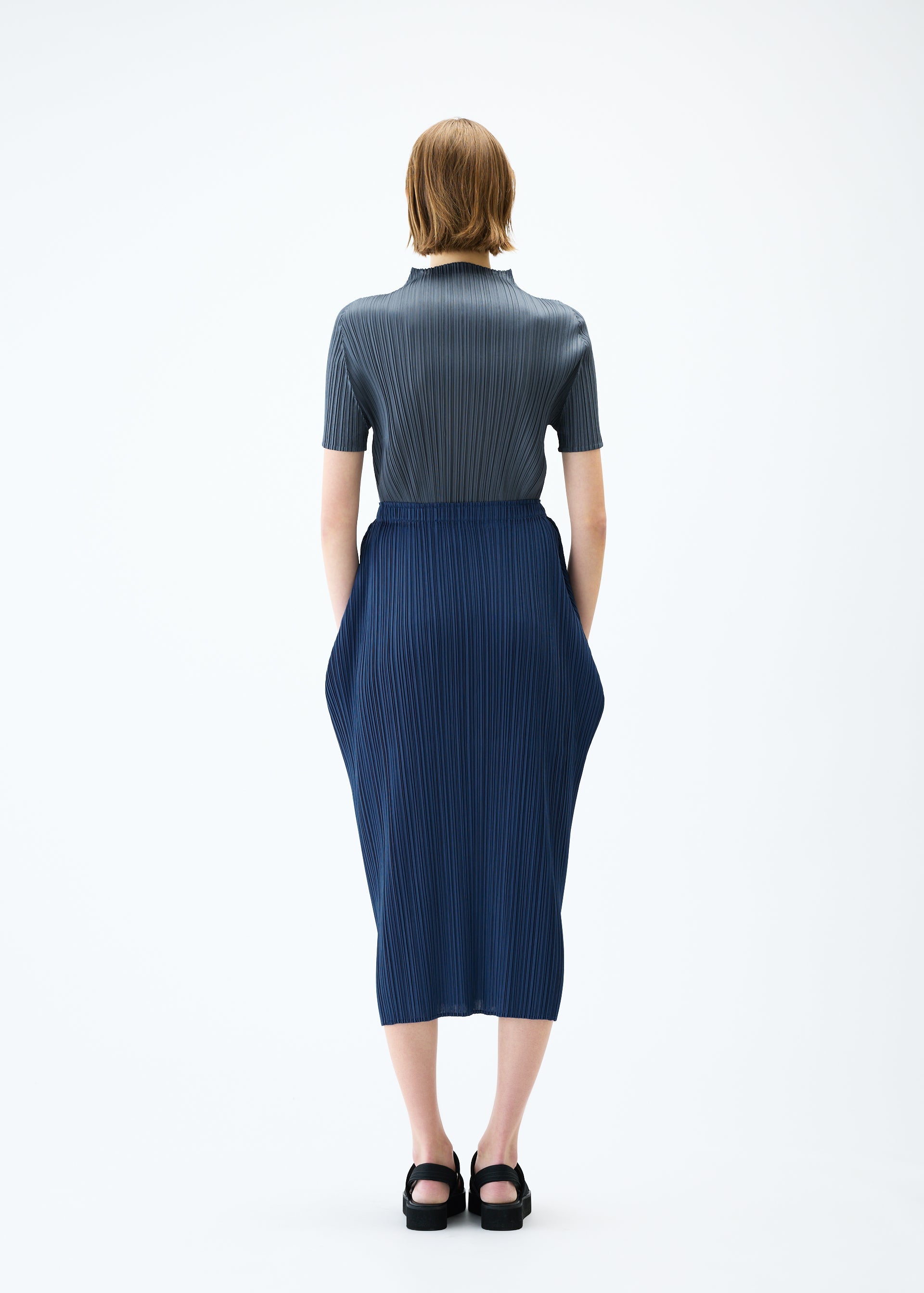 A model wears the PLEATS PLEASE ISSEY MIYAKE LAMP SHADE skirt.