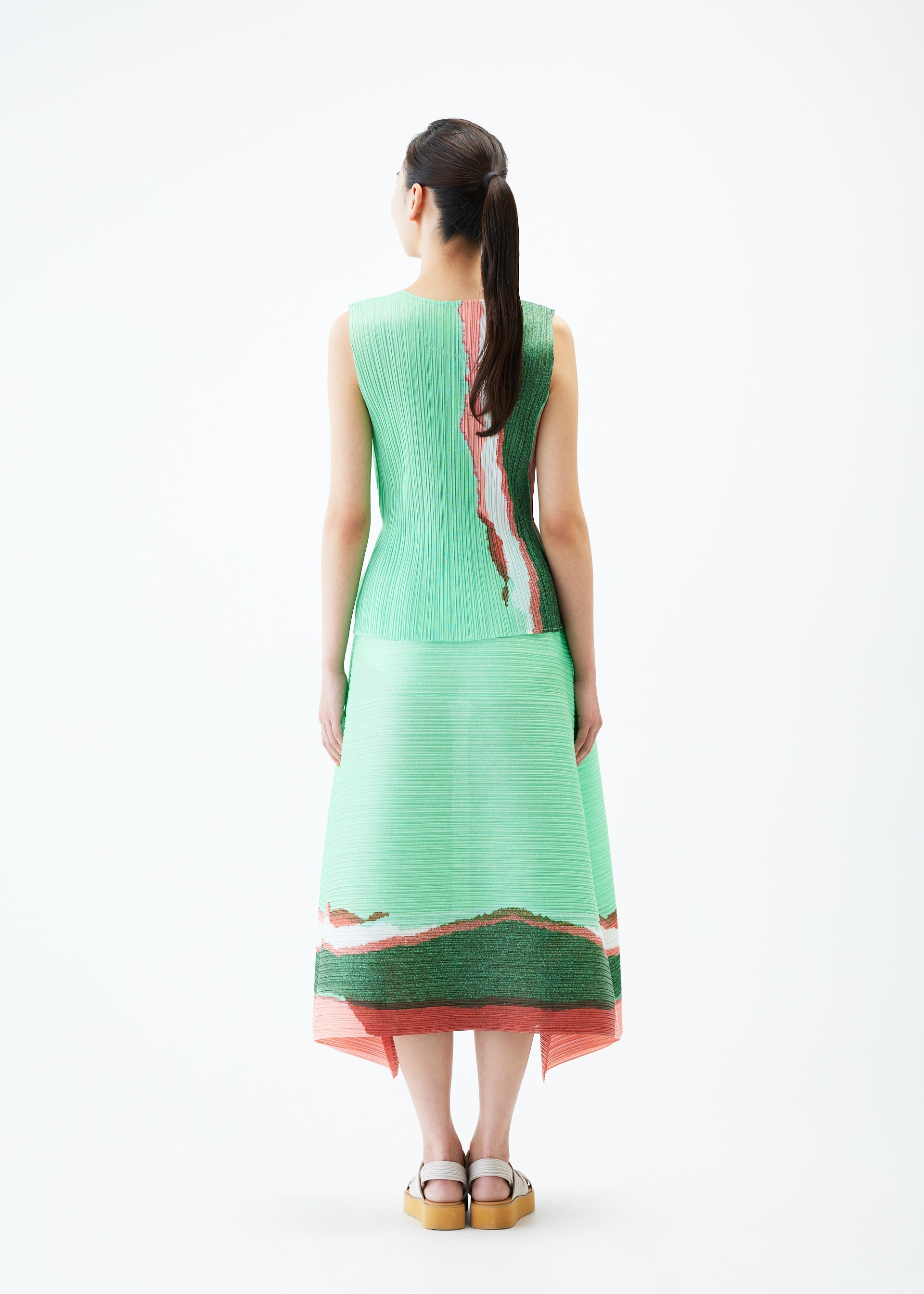 A model wears the PLEATS PLEASE ISSEY MIYAKE GRAINY COLORS skirt.