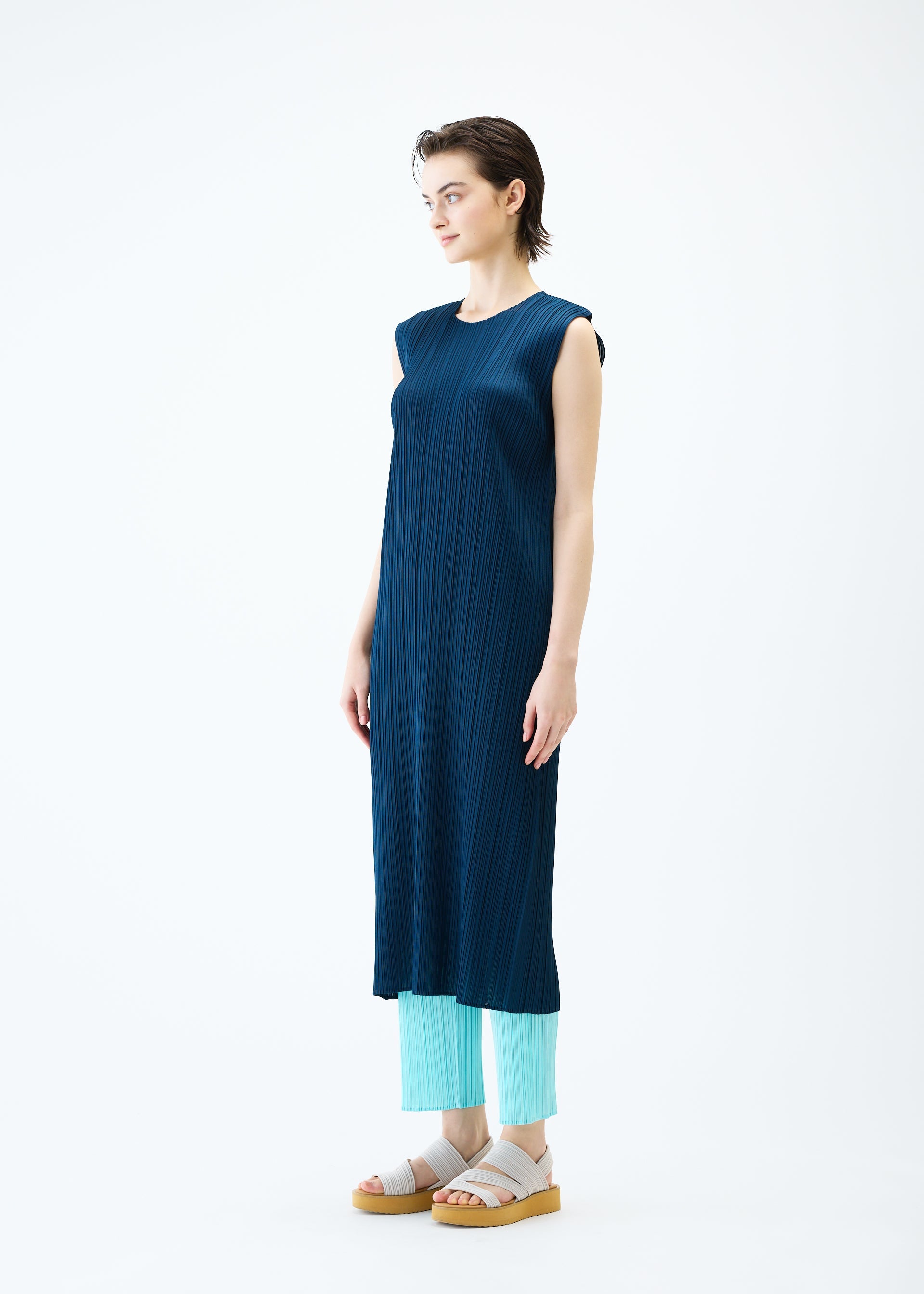 A model wears the PLEATS PLEASE ISSEY MIYAKE MONTHLY COLORS APRIL dress.