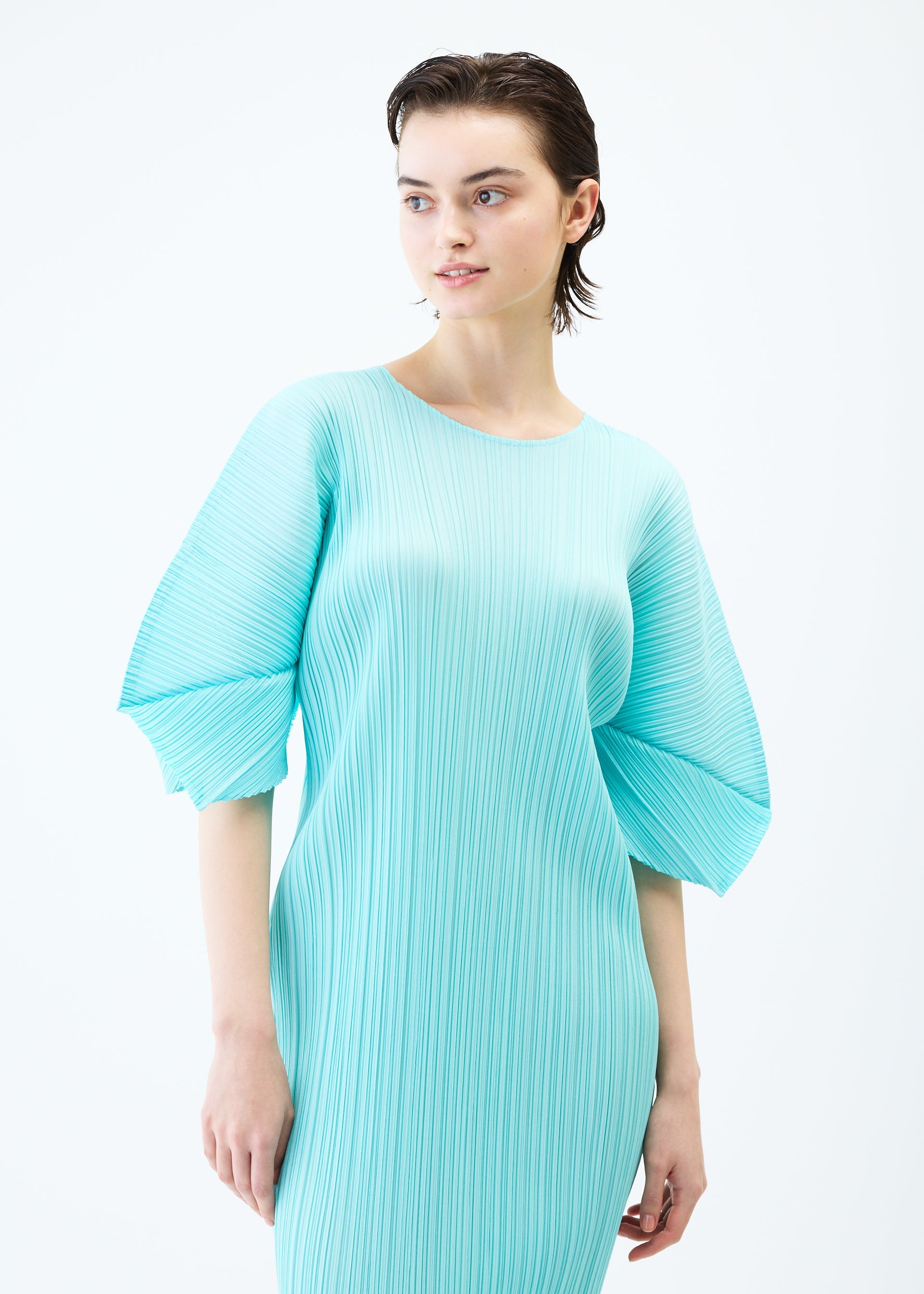 A model wears the PLEATS PLEASE ISSEY MIYAKE MONTHLY COLORS APRIL dress.