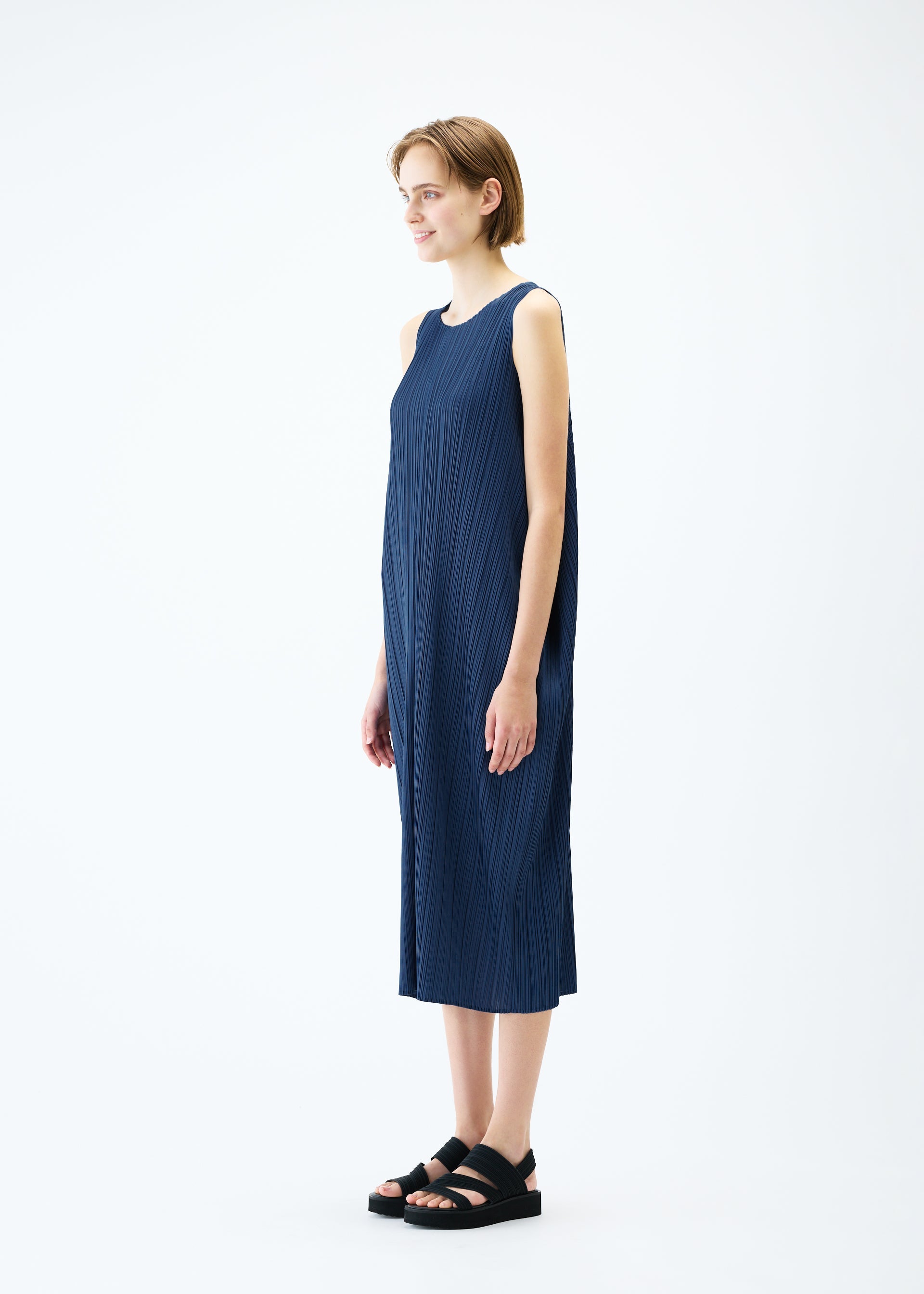 A model wears the PLEATS PLEASE ISSEY MIYAKE LAMP SHADE dress.