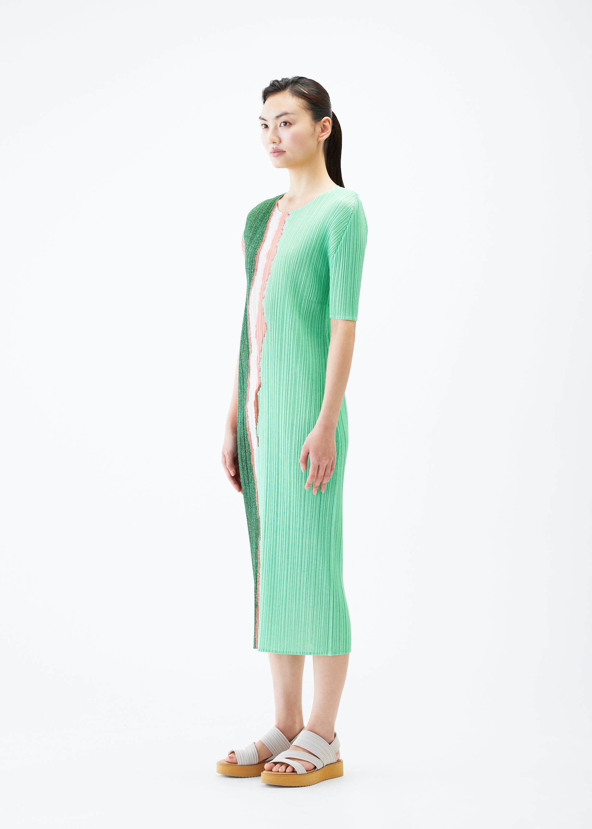 A model wears the PLEATS PLEASE ISSEY MIYAKE GRAINY COLORS dress.