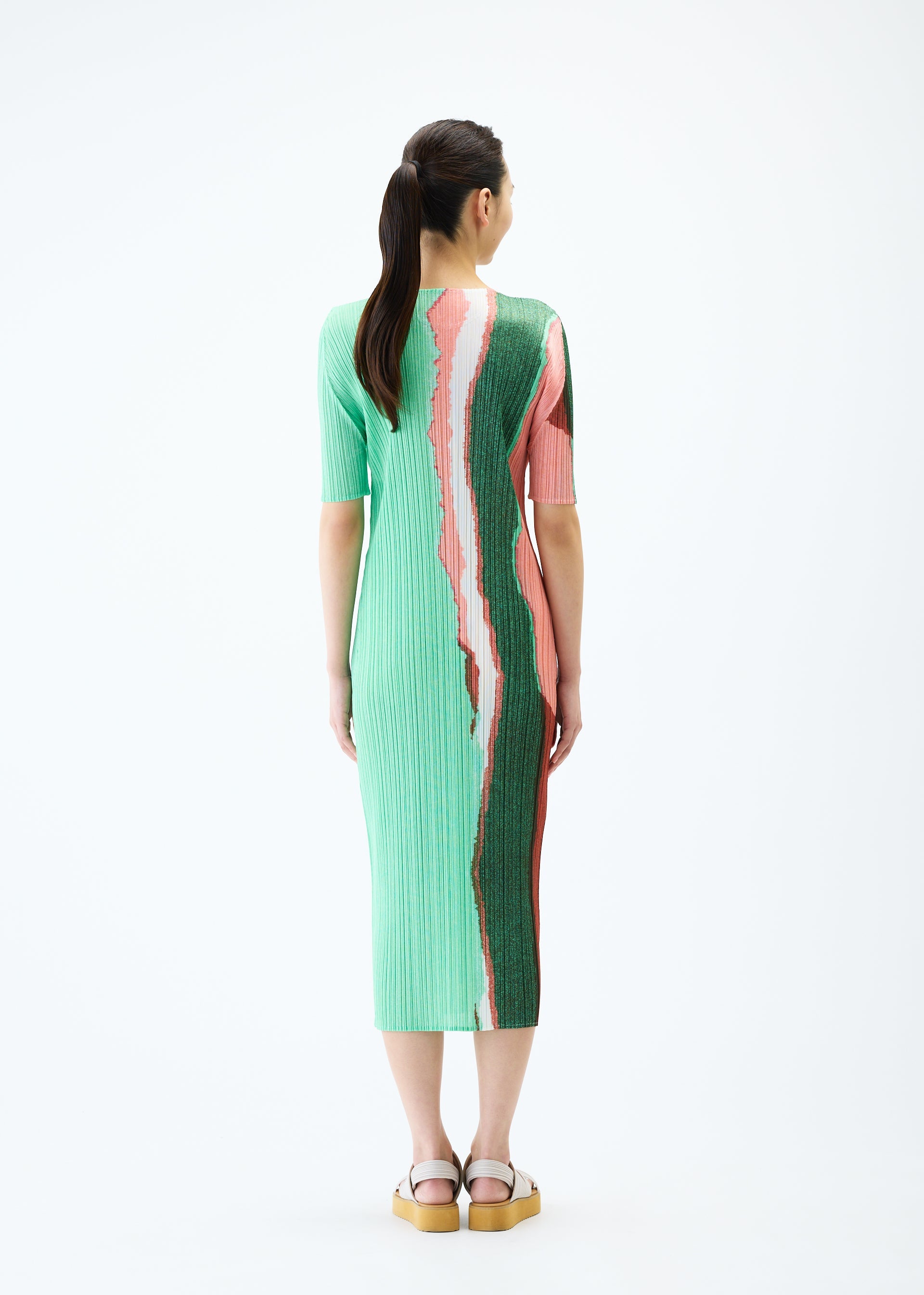 A model wears the PLEATS PLEASE ISSEY MIYAKE GRAINY COLORS dress.