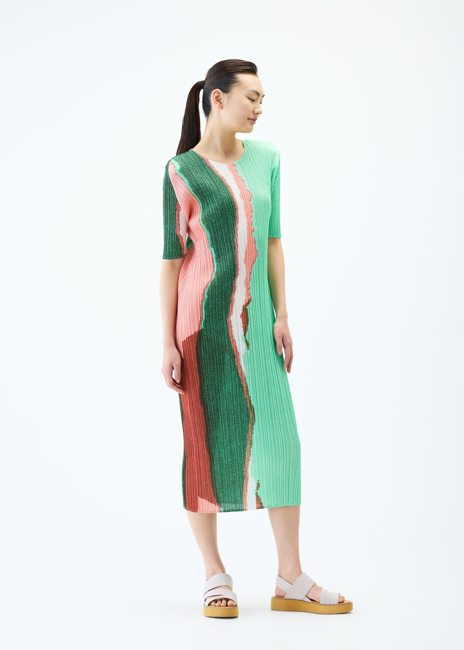 A model wears the PLEATS PLEASE ISSEY MIYAKE GRAINY COLORS dress.