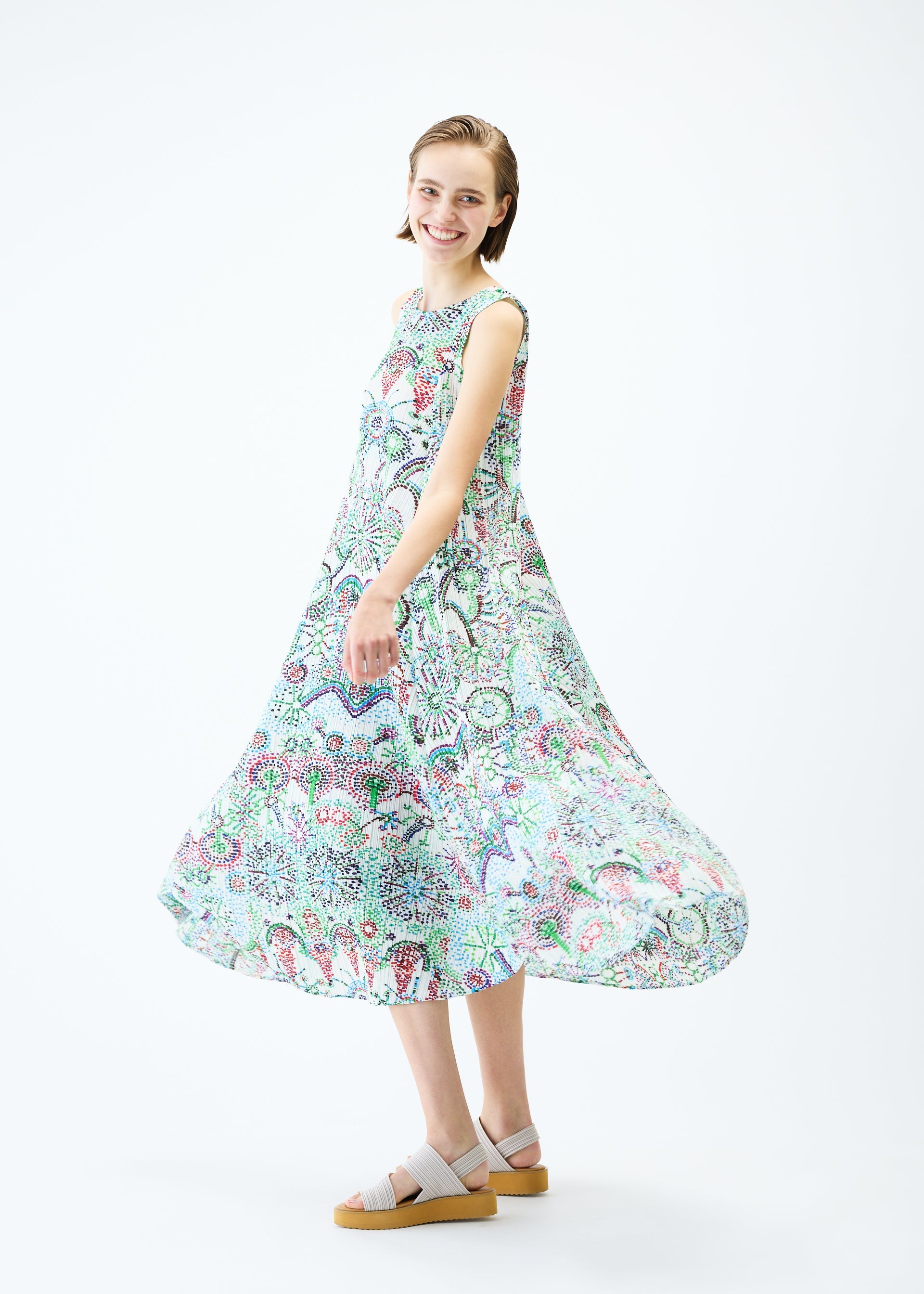A model wears the PLEATS PLEASE ISSEY MIYAKE LIGHT FESTIVAL dress.