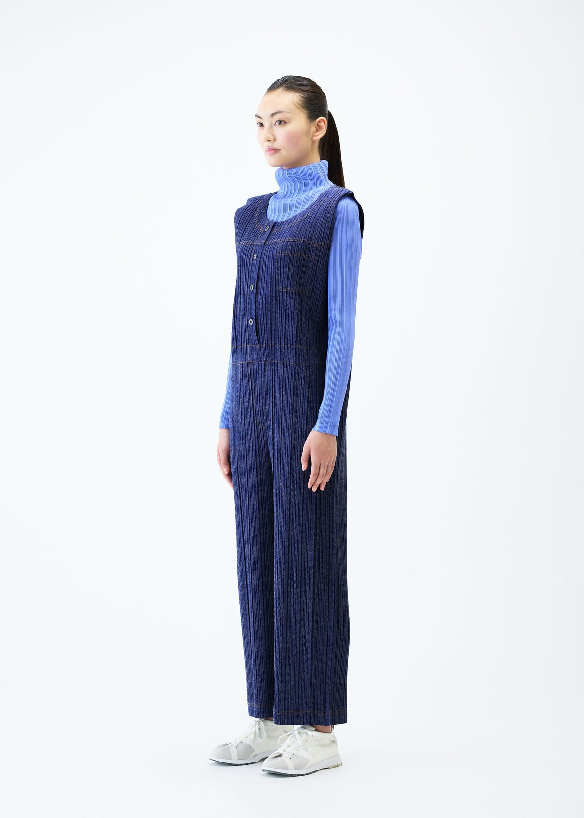 A model wears the PLEATS PLEASE ISSEY MIYAKE COTTON DENIM jumpsuit.