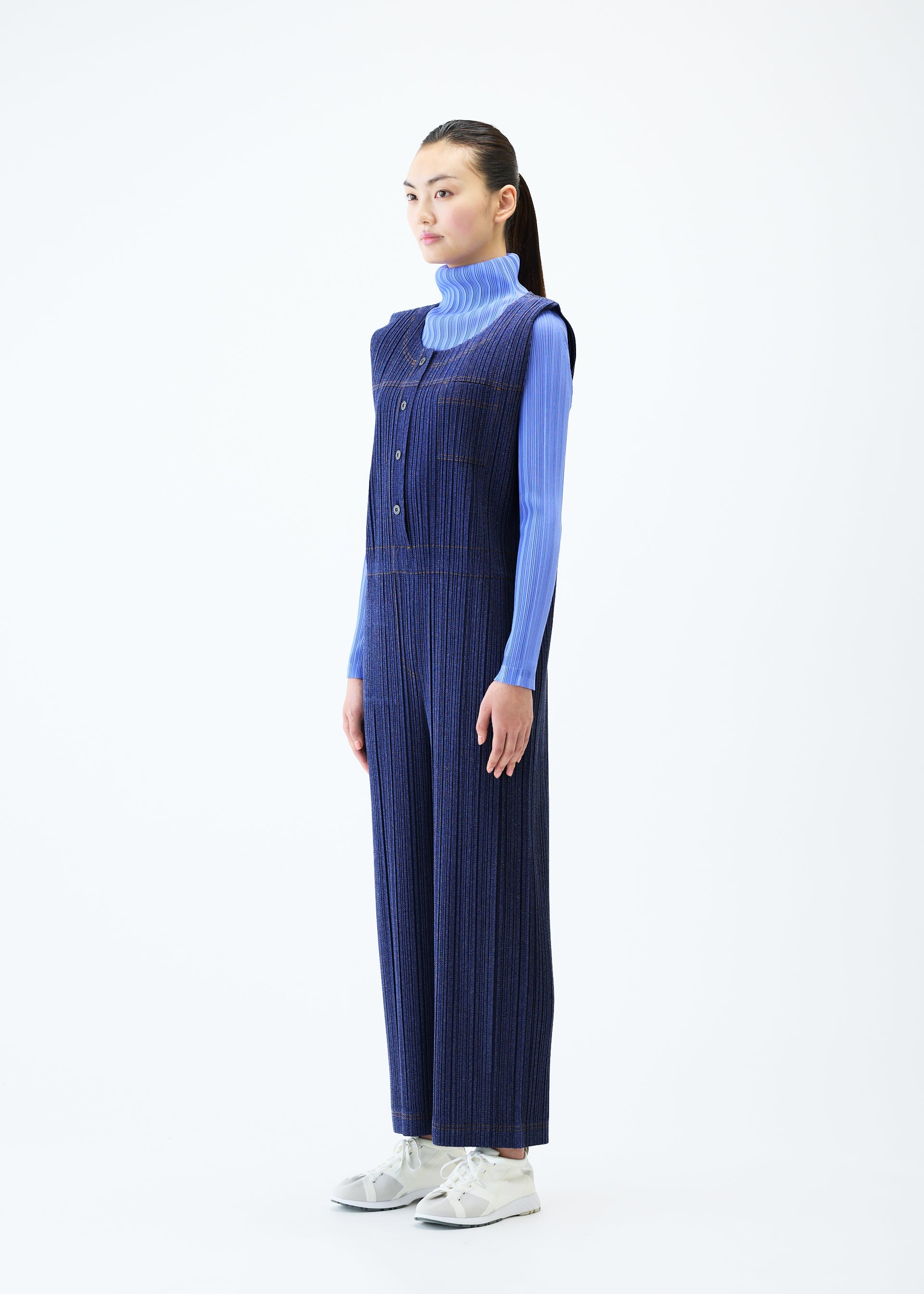 A model wears the PLEATS PLEASE ISSEY MIYAKE COTTON DENIM jumpsuit.