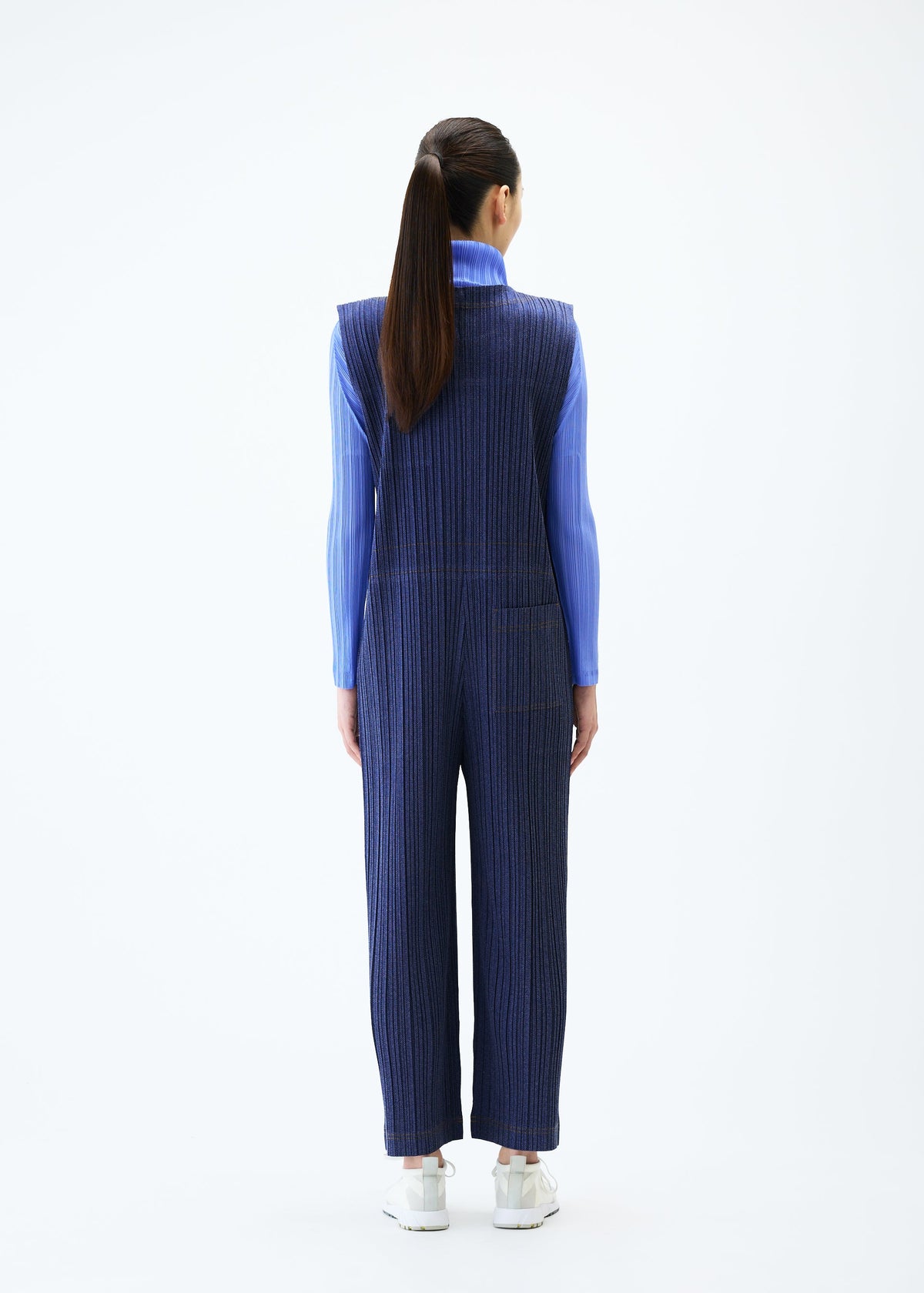 A model wears the PLEATS PLEASE ISSEY MIYAKE COTTON DENIM jumpsuit.