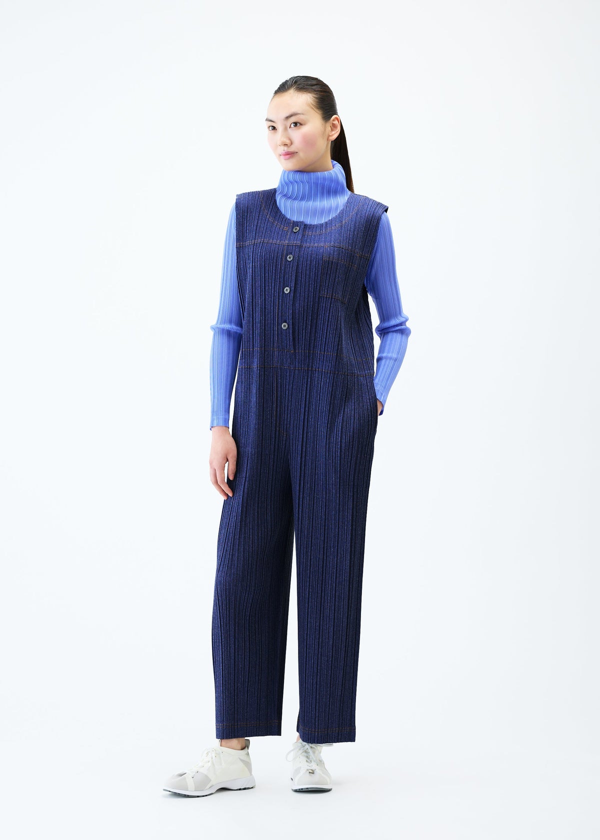 A model wears the PLEATS PLEASE ISSEY MIYAKE COTTON DENIM jumpsuit.