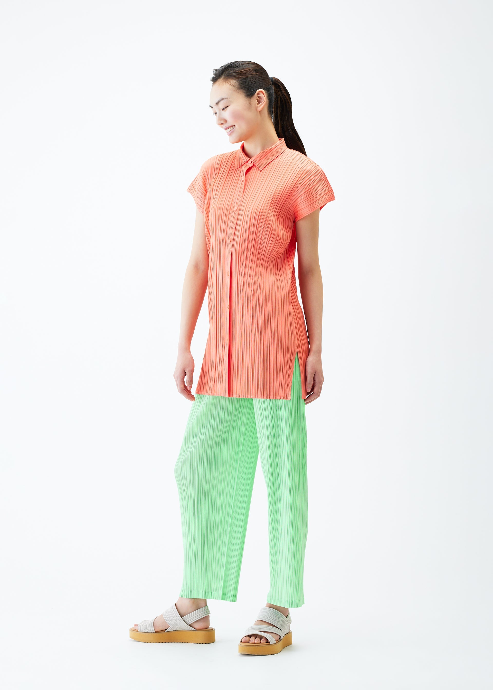 A model wears the PLEATS PLEASE ISSEY MIYAKE MONTHLY COLORS MAY shirt.