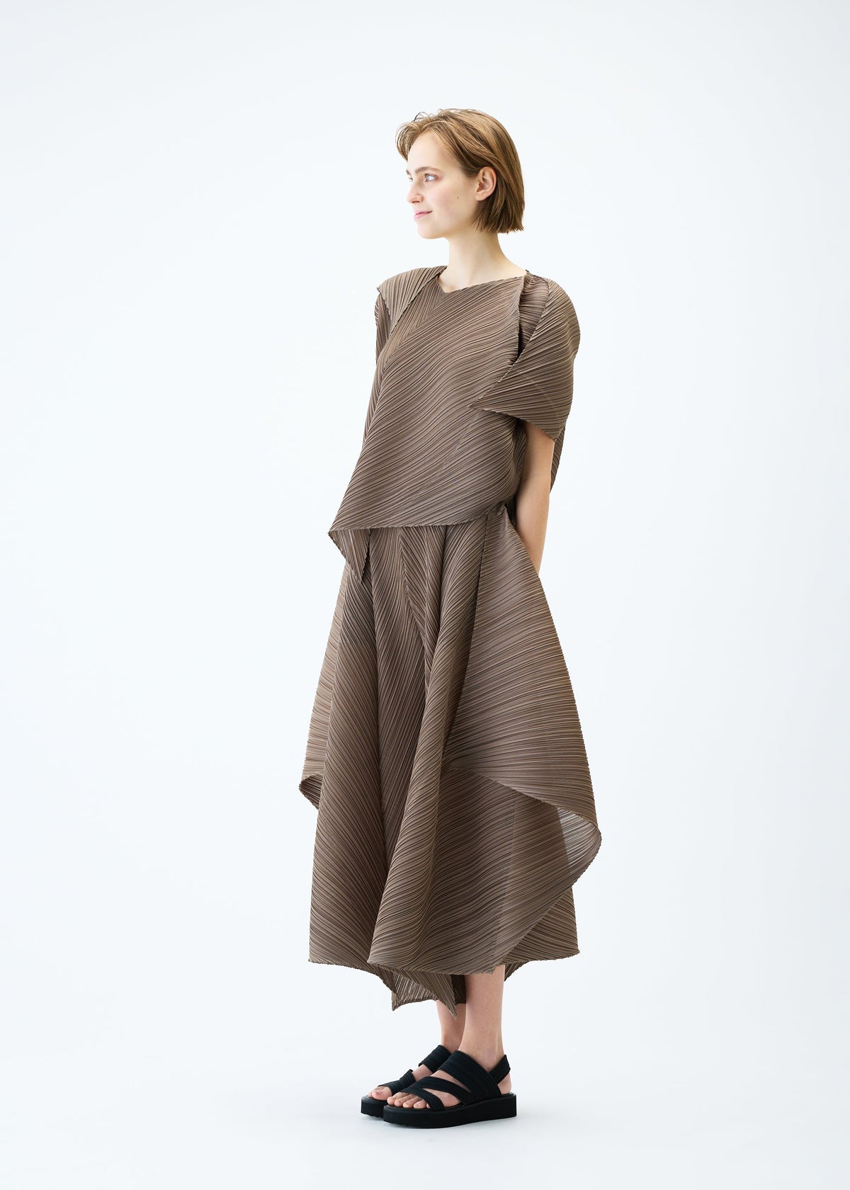 A model wears the PLEATS PLEASE ISSEY MIYAKE FLARE top.