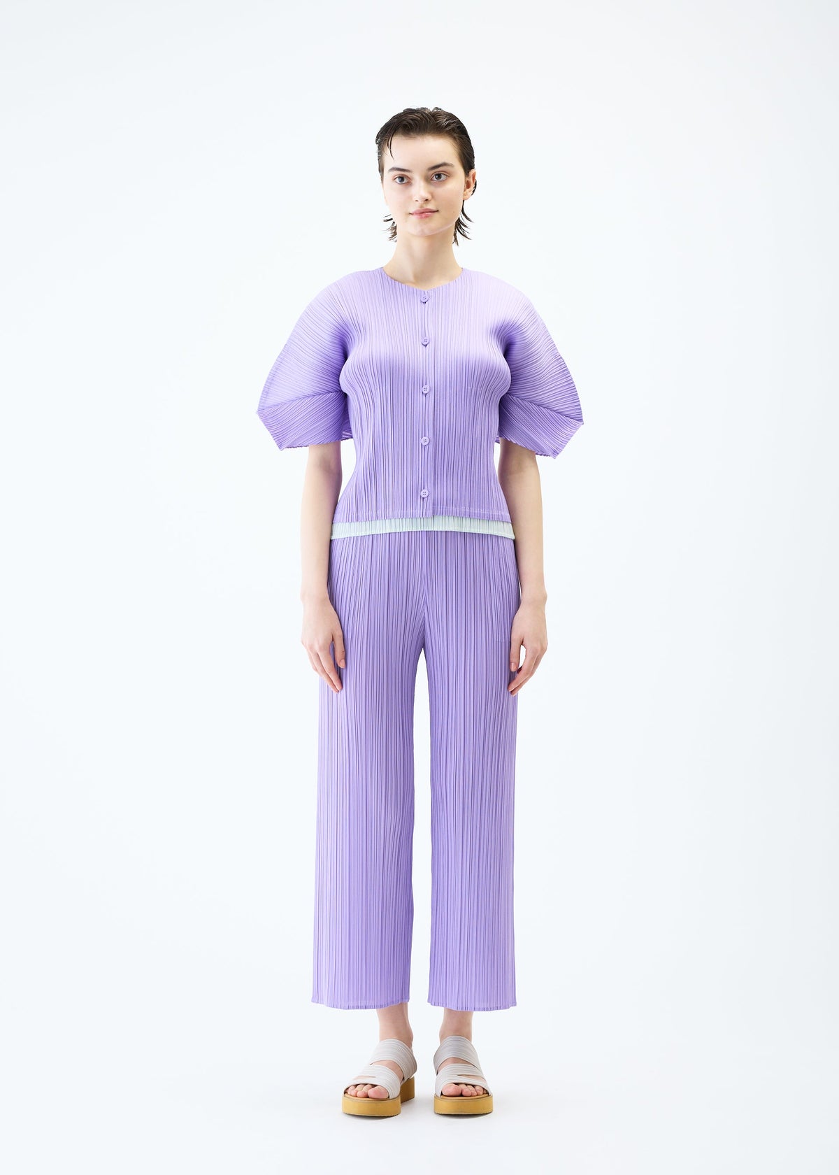 A model wears the PLEATS PLEASE ISSEY MIYAKE MONTHLY COLORS APRIL cardigan.