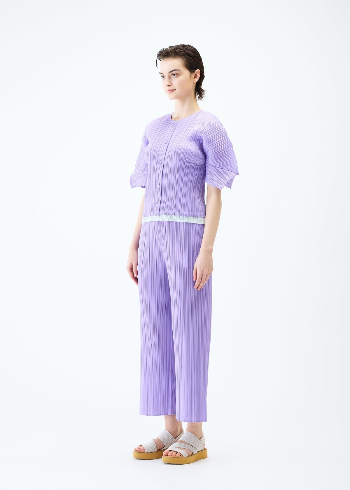 A model wears the PLEATS PLEASE ISSEY MIYAKE MONTHLY COLORS APRIL cardigan.